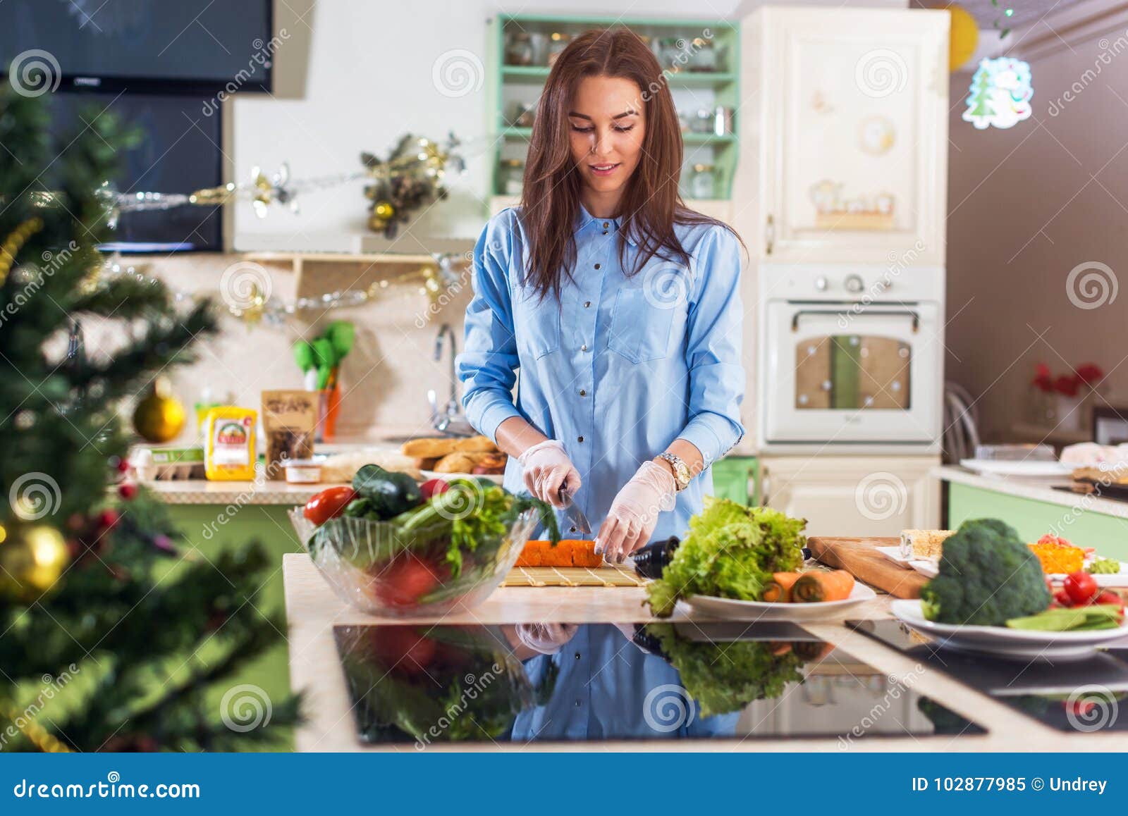 young caucasian lady cooking new year or christmas meal in decorated kitchen at home