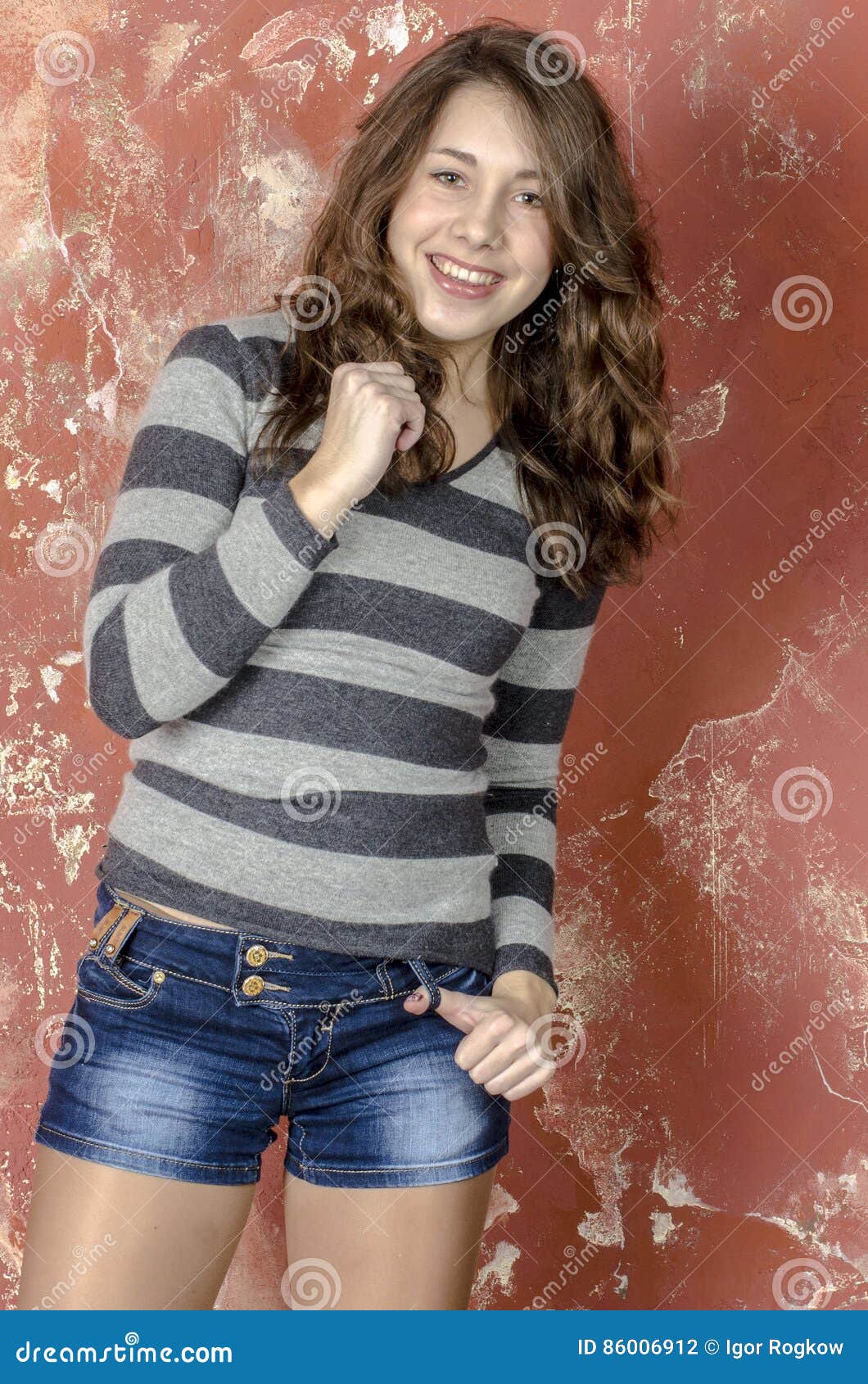 Young Cheerful Girl in Denim Shorts and a Striped Sweater Walking in ...