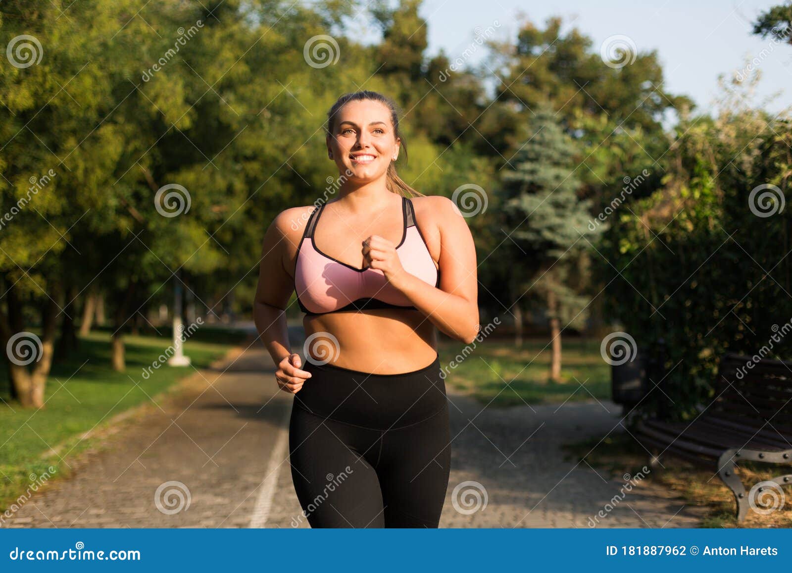Young beautiful plus size woman in sporty top and leggings with