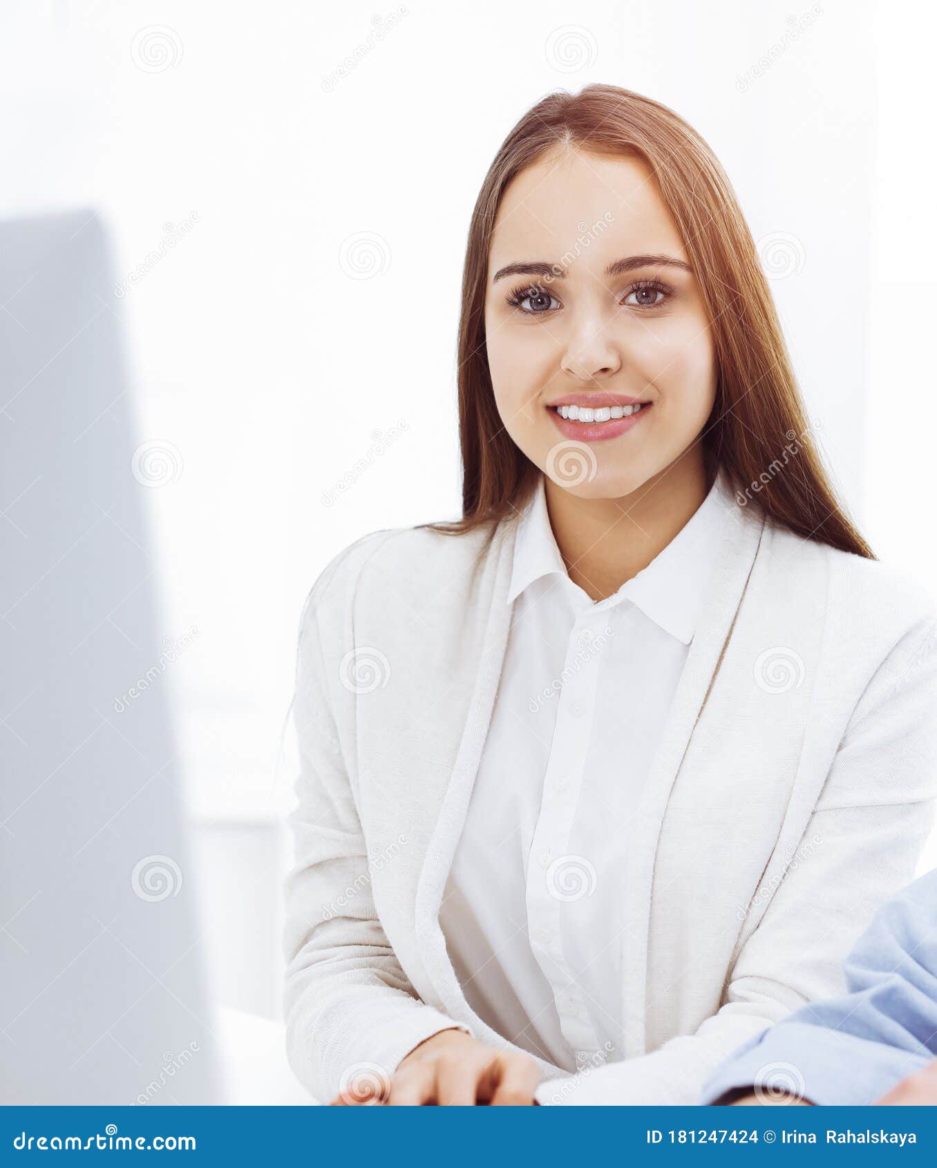 Young Cheerful Woman Sitting at the Desk with Computer and Looking at ...