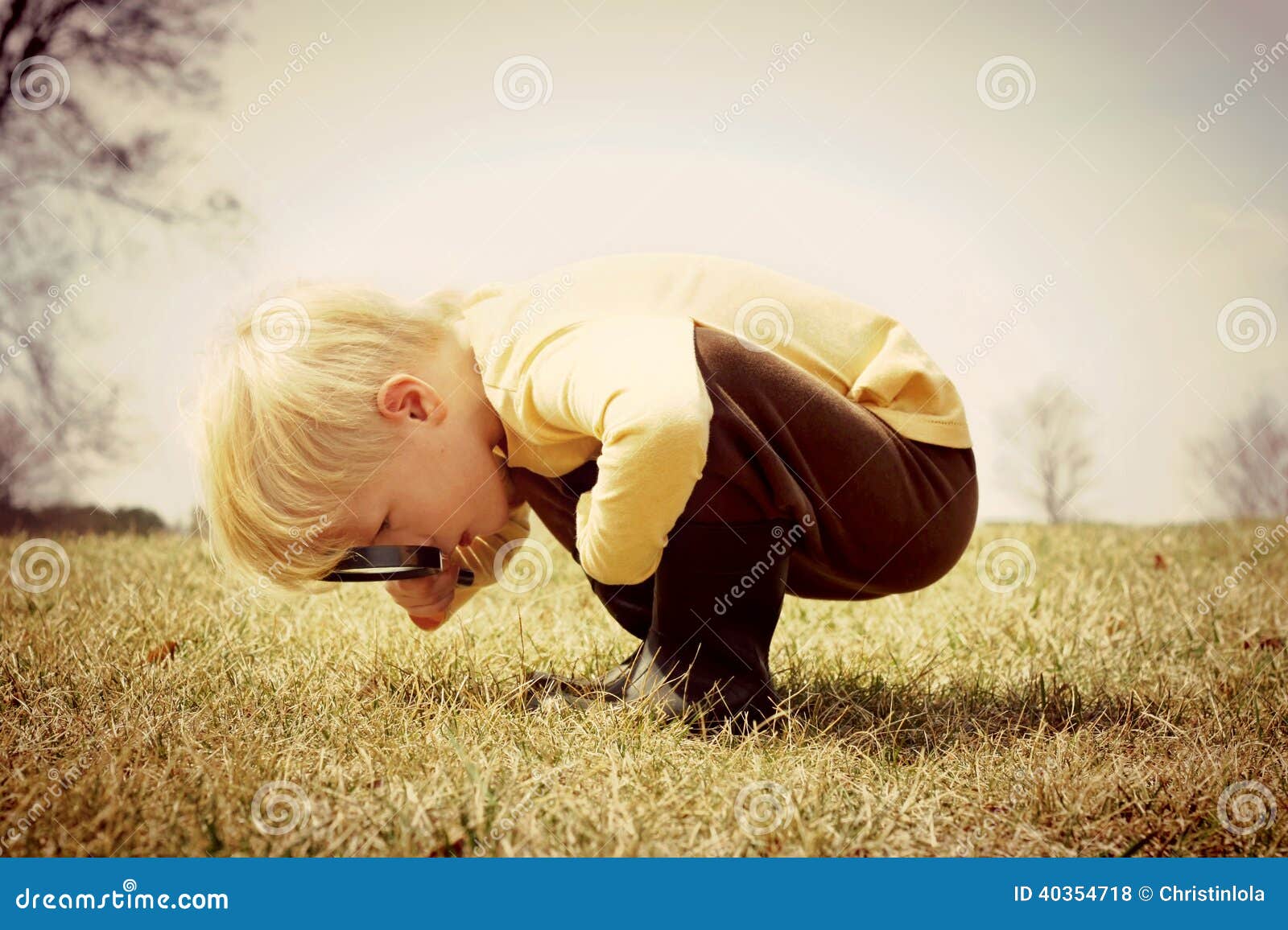 young child looking through magnifying glass