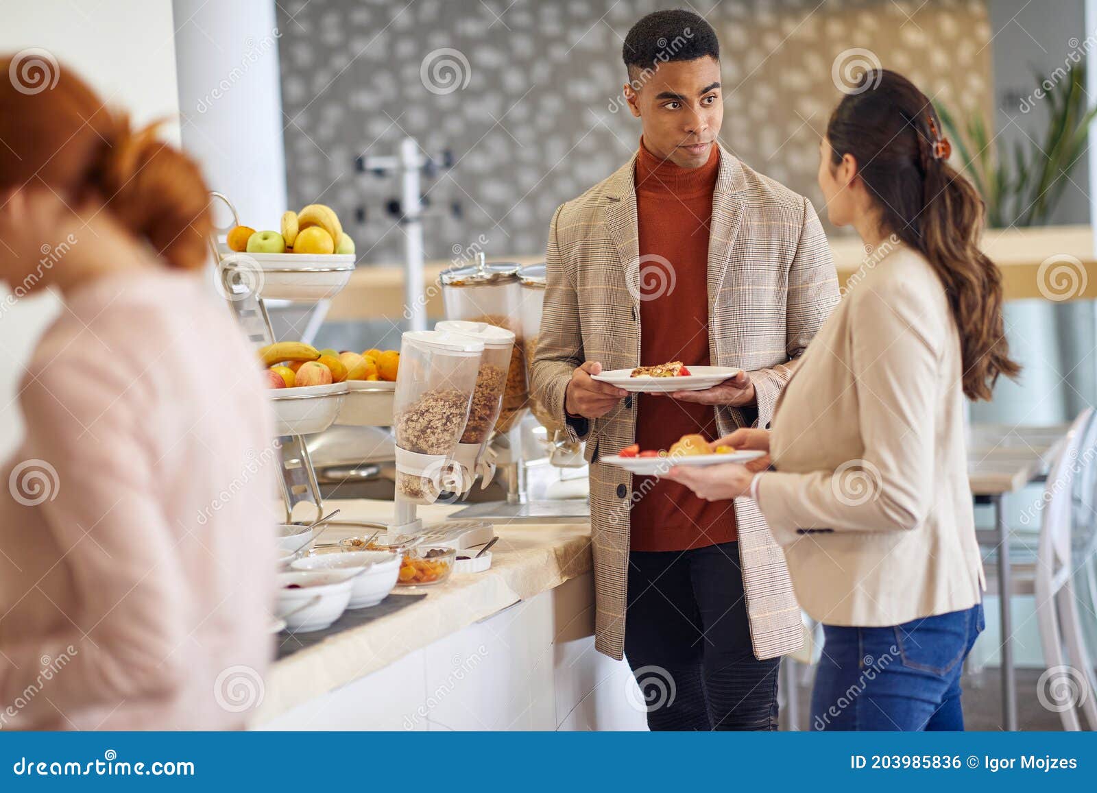 young colleagues talking while picking a food at company canteen. people, job, company, business concept