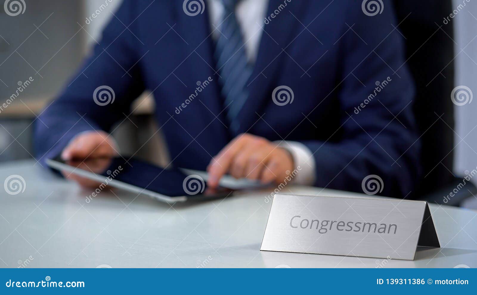young congressman using tablet pc, reading political news online, election