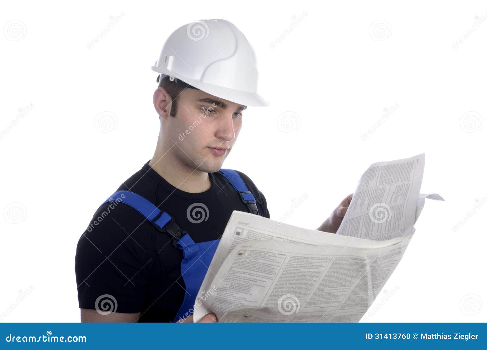 Young Construction Worker Studying Newspaper for Jobs Stock Photo