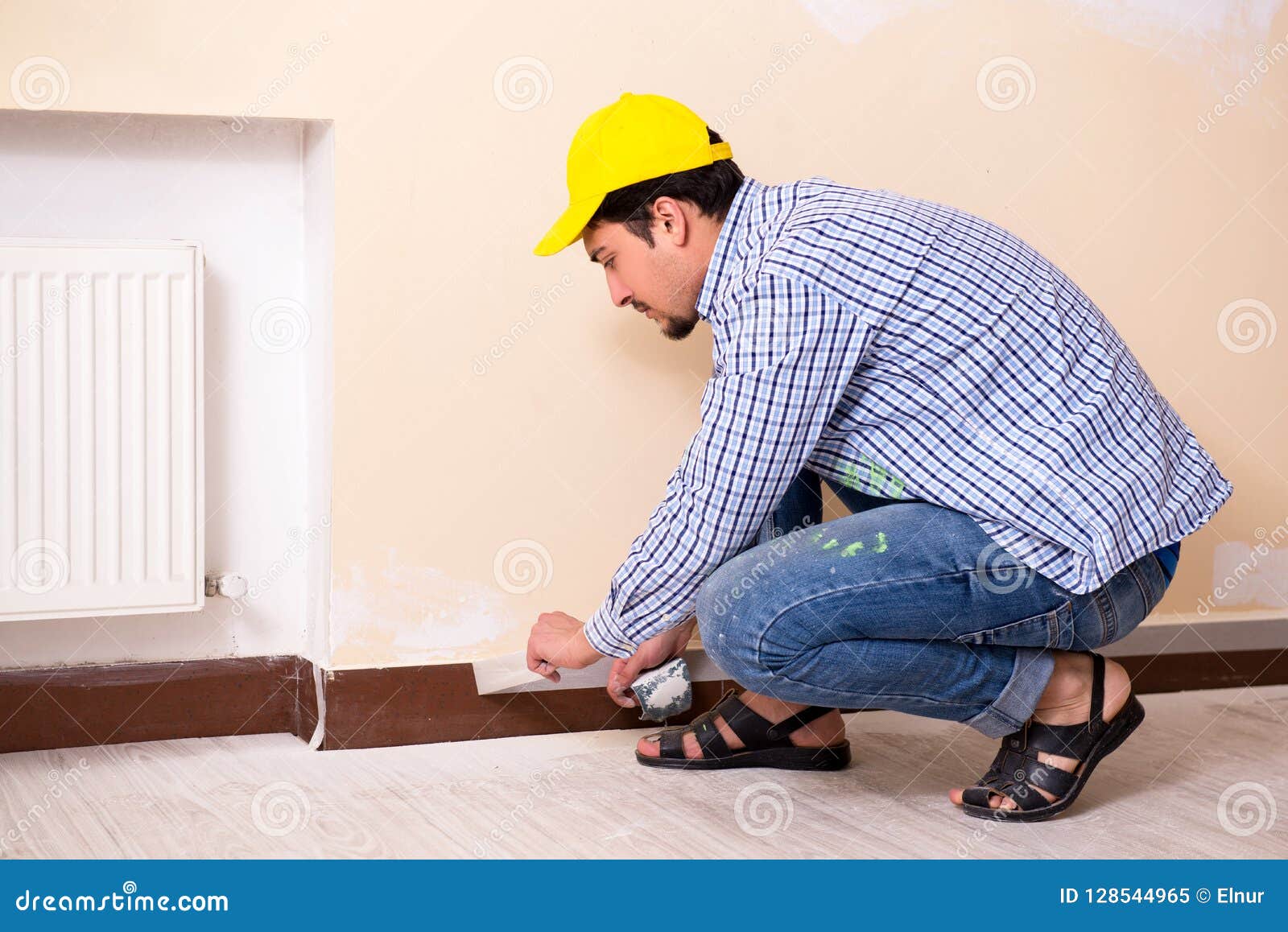 The Young Contractor Sanding Wall Down with Sandpaper Stock Image