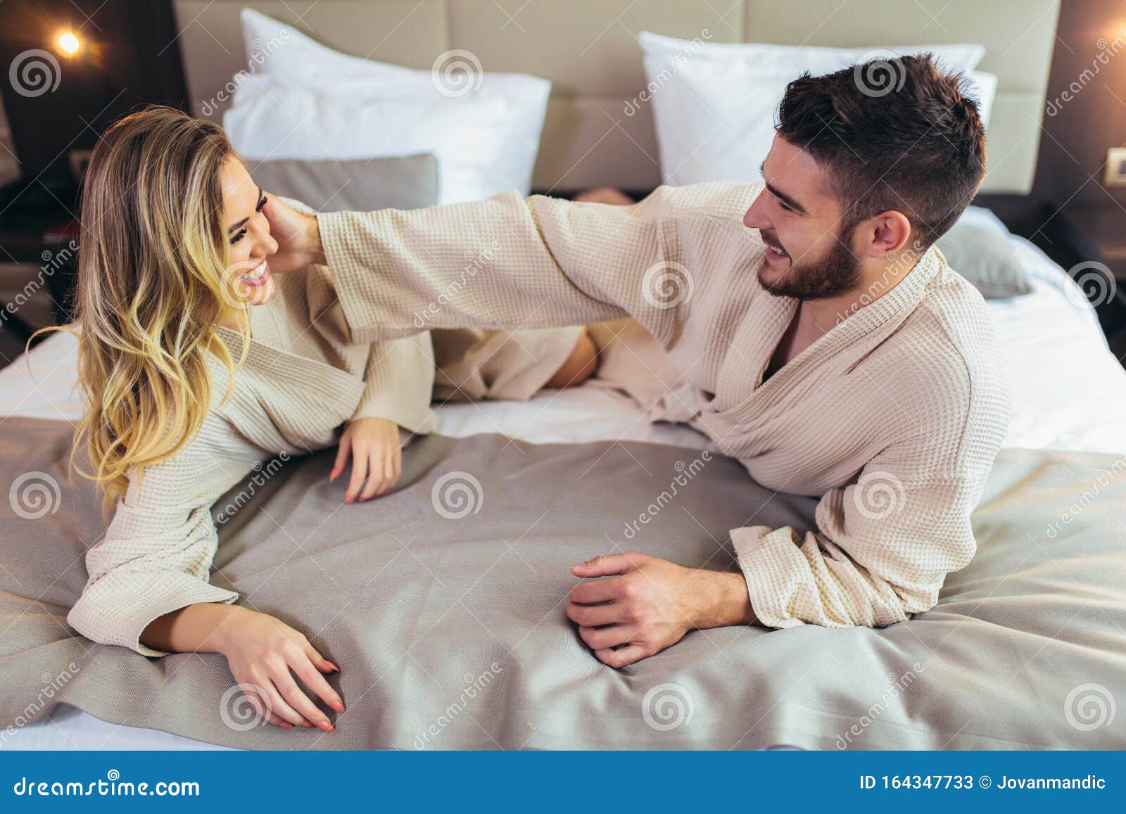 Couple In Bathrobes Lying On Bed In Hotel Room Stock Image Image Of