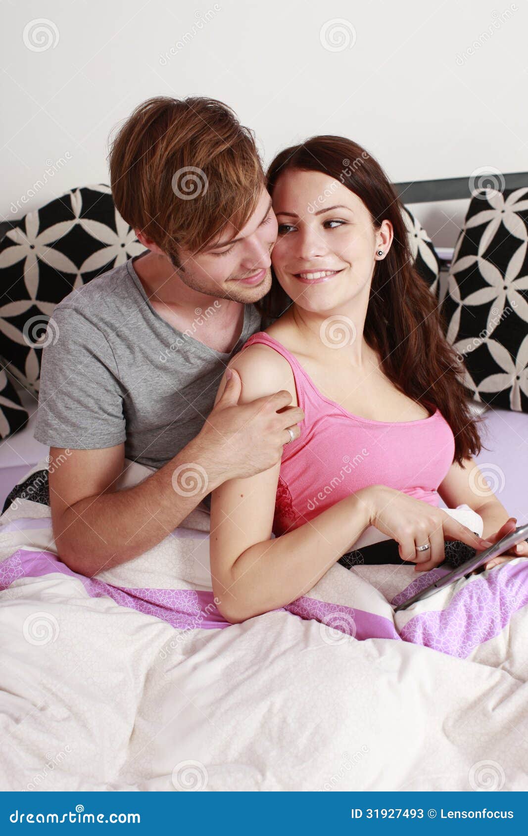 Young Couple In The Bedroom With Tablet Comp