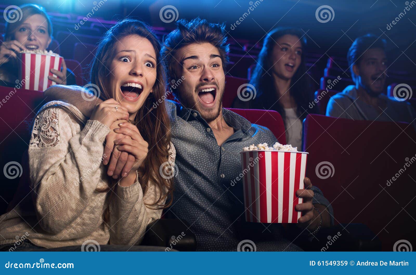 young couple at the cinema watching an horror movie