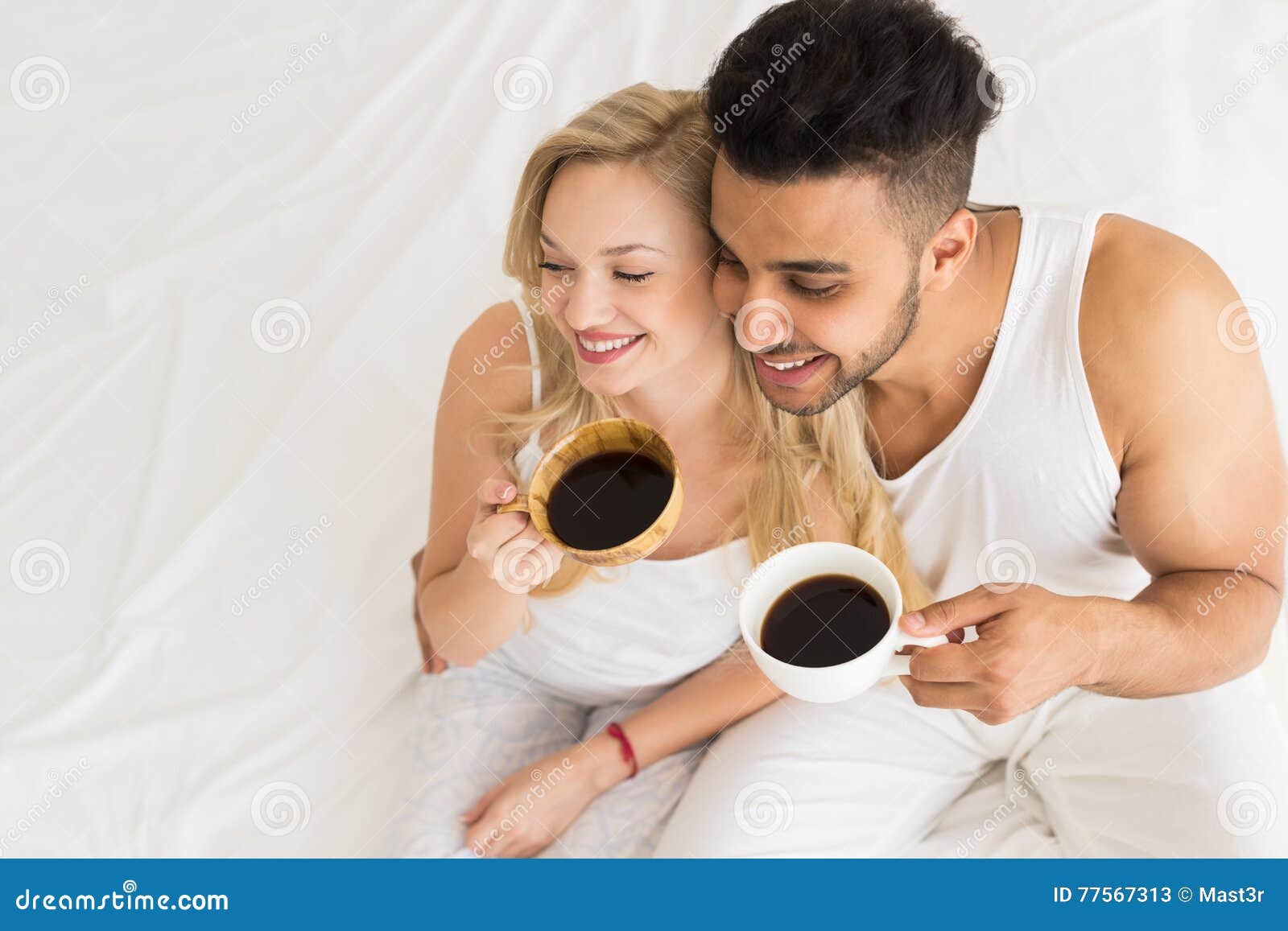 Young Couple Drink Coffee Sitting In Bed Happy Smile Hispanic Man