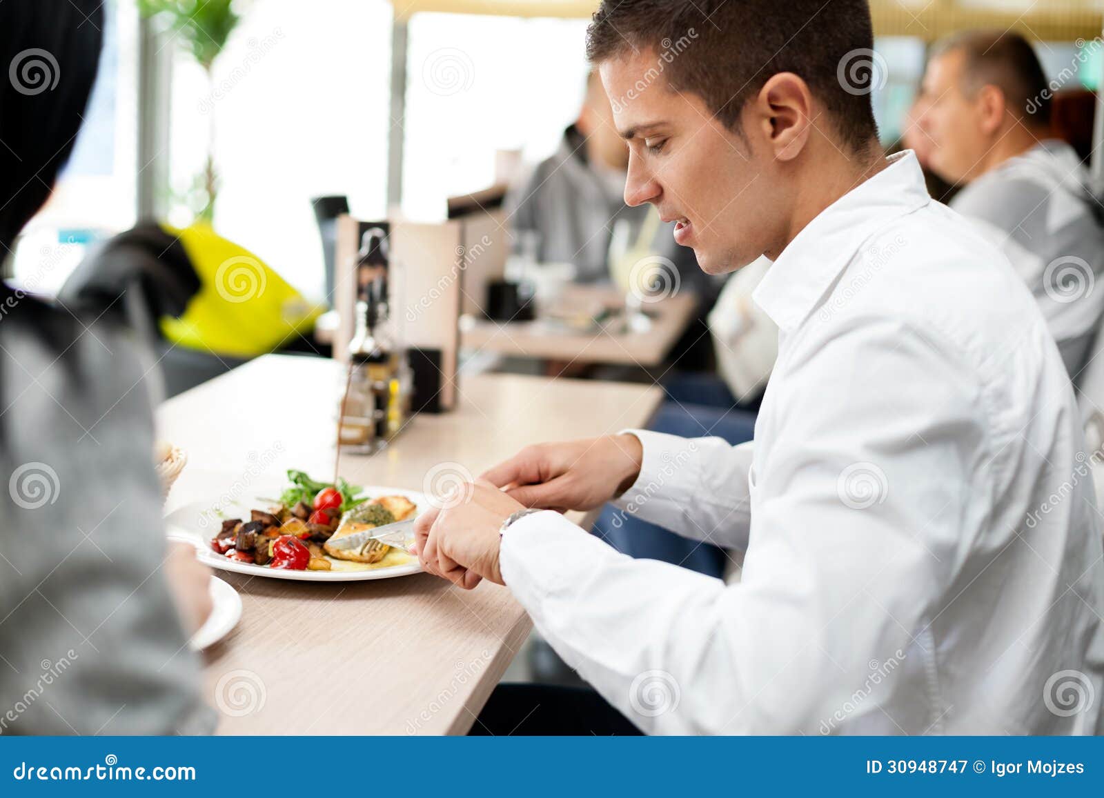 Что не следует класть на стол. Мужчина обедает в ресторане. Мужчина обедает в столовой. Мужчина в столовой. Локти на столе.