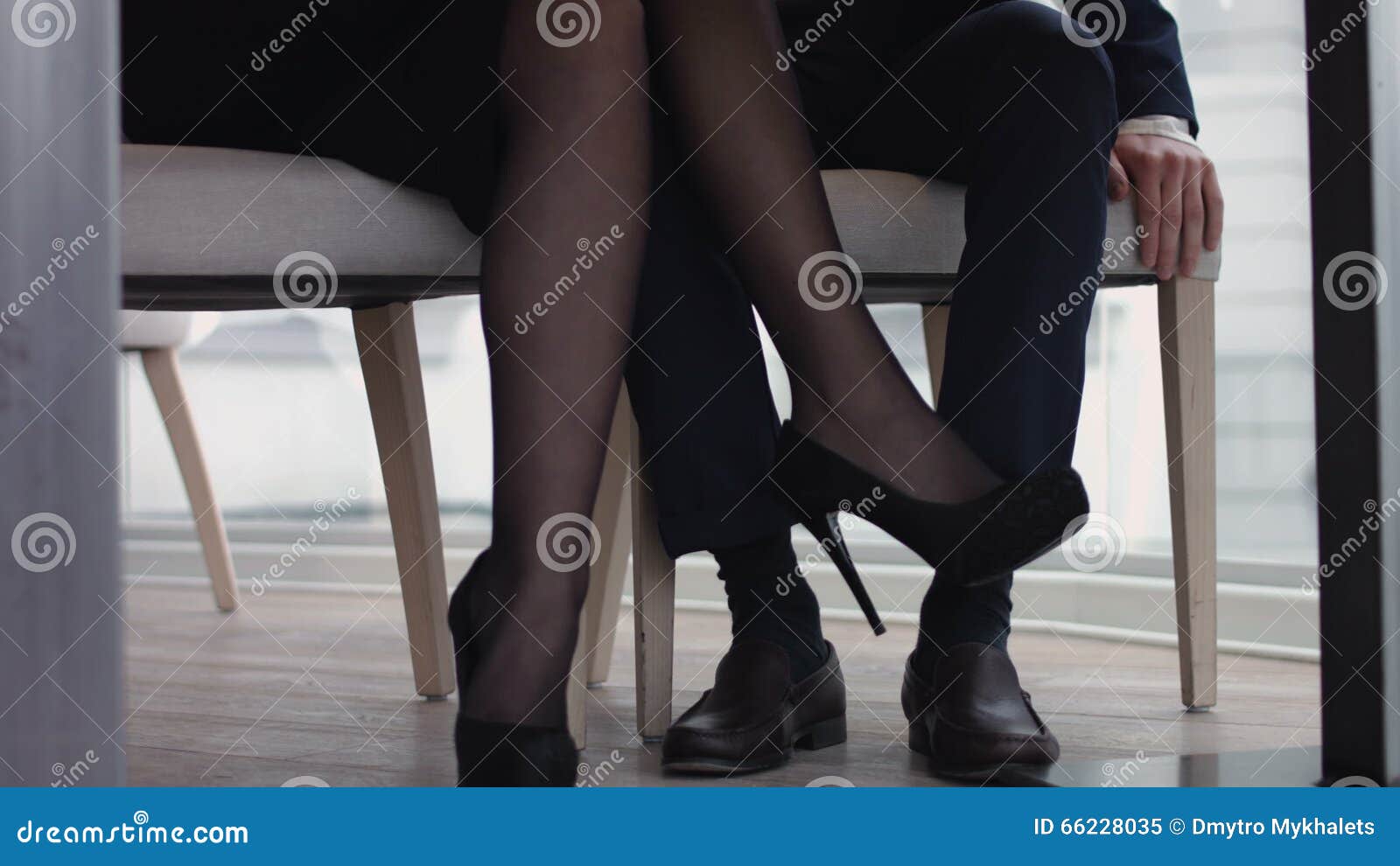 Young Couple Flirting with Legs at the Restaurant Under the Table Stock