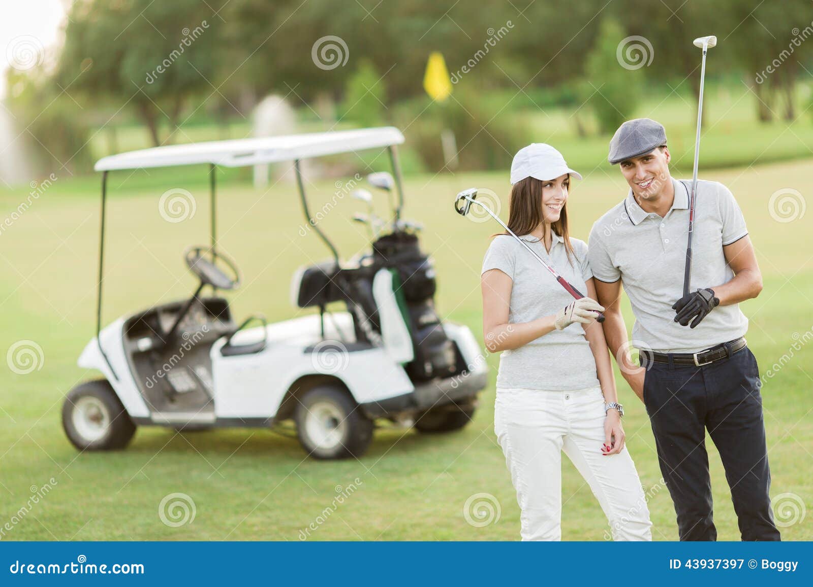 Young couple at golf court. Young couple by the golf cart