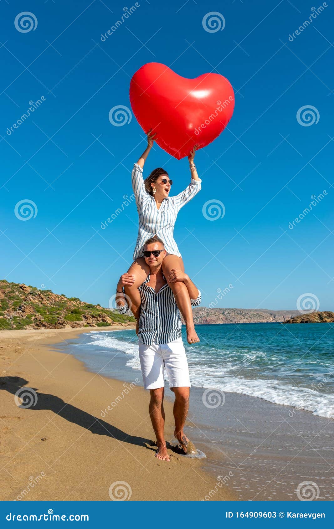 Young Couple Having Fun On The Beach With A Big Heart Balloon Summer Love Concept Stock Image