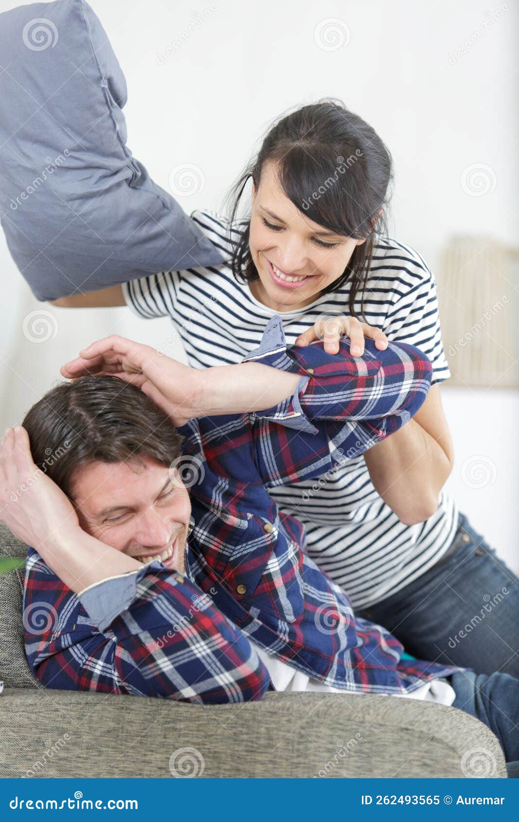 Young Couple Having Pillow Fight on Sofa Stock Image Image of