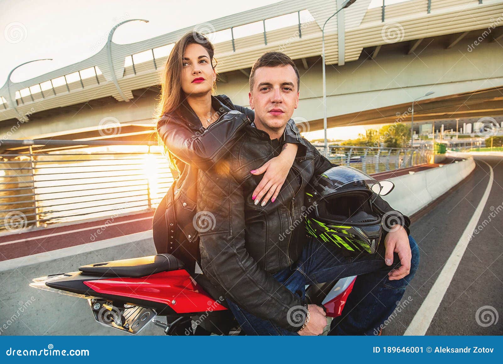 Young Couple Hugging while Sitting on Red Sports Motorcycle at Bridge ...