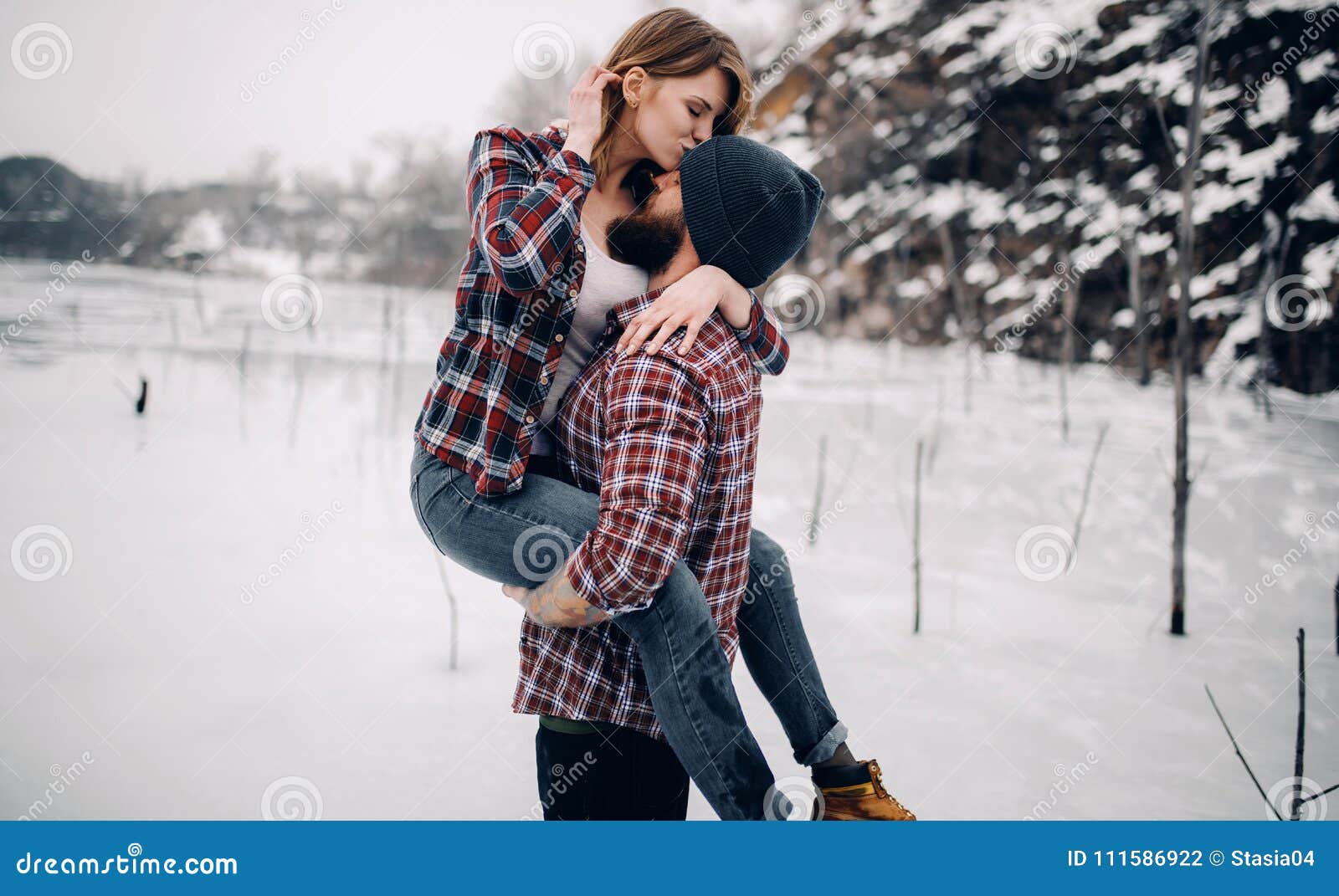 Young Couple Hugs and Kisses during Winter Walk. Stock Photo ...