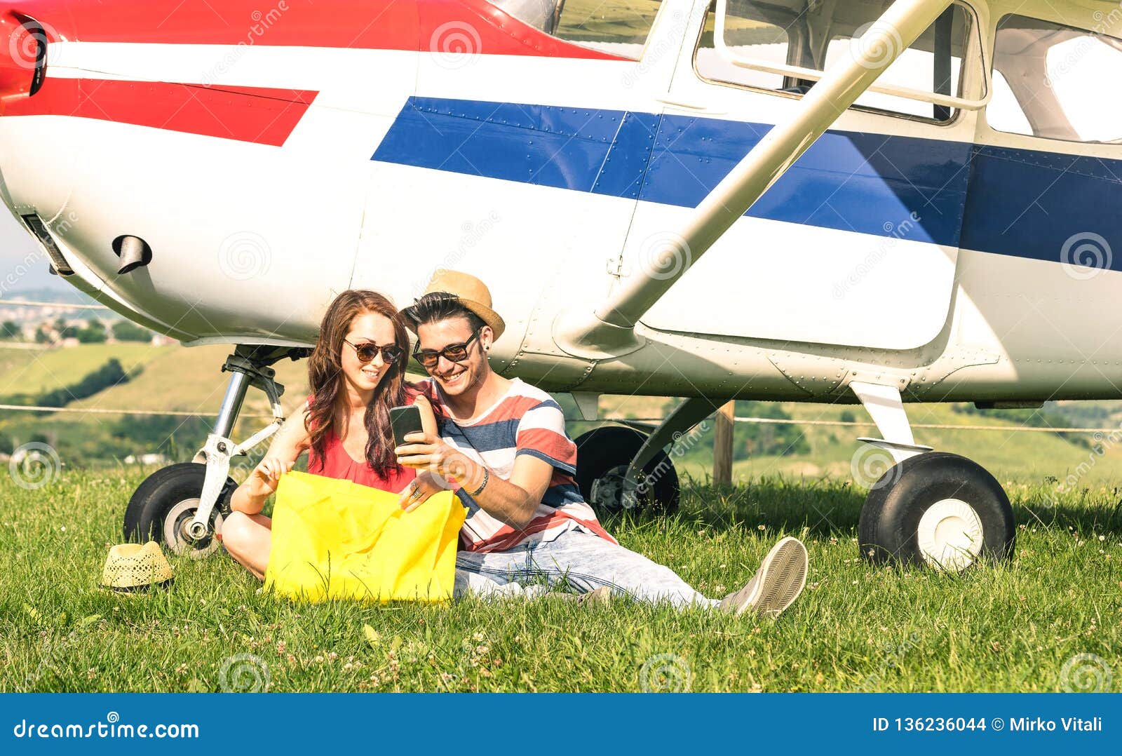 young couple of lovers having a rest during charter airplane excursion - wanderlust concept of alternative people lifestyle