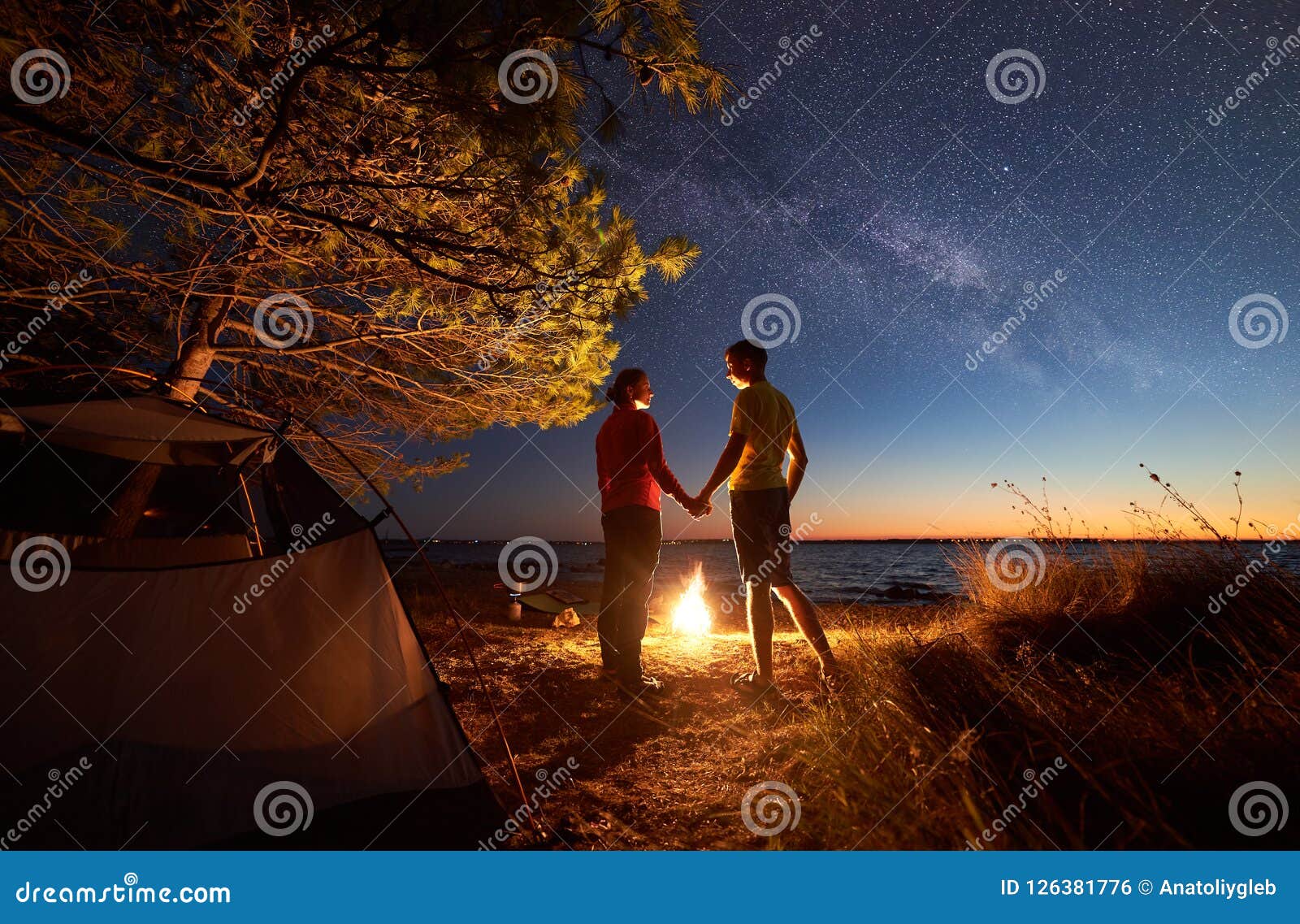 Young Couple Man and Woman Having Rest at Tourist Tent and Burning Campfire on Sea Shore Near Stock Photo Image of family, leisure: 126381776