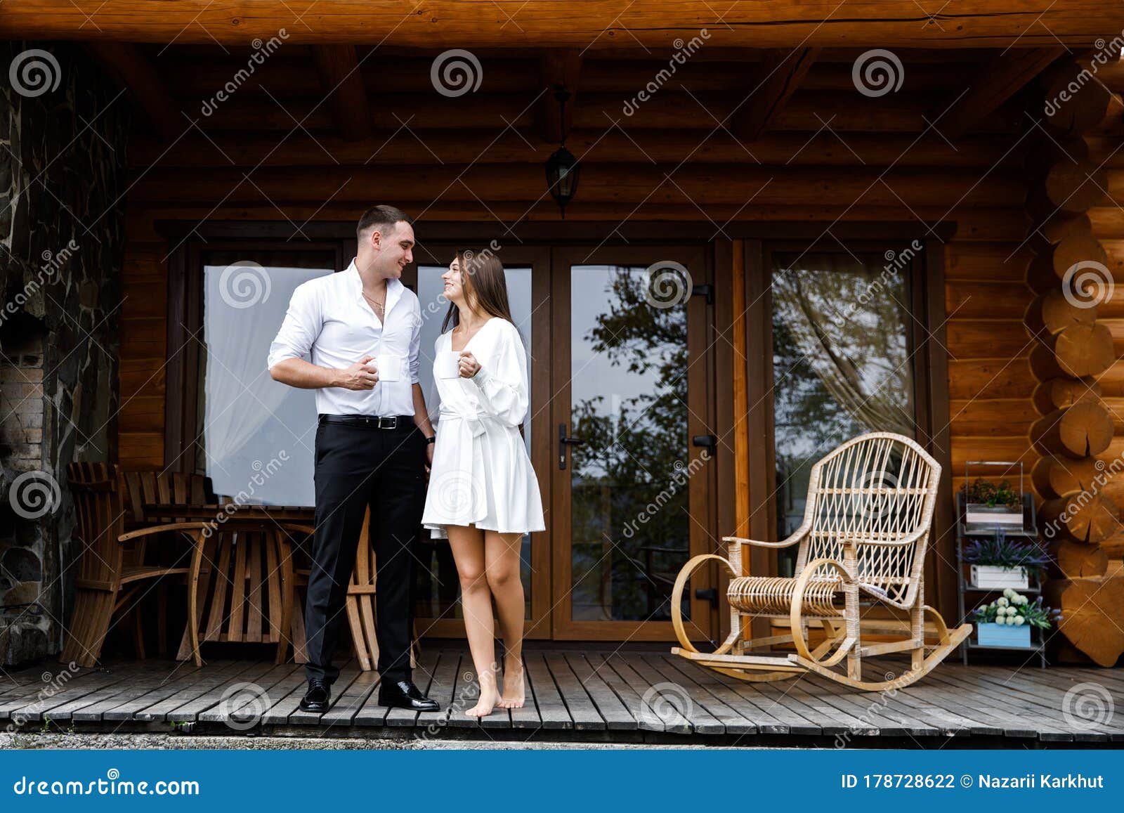 Young Couple - Man and Woman Relaxing on Terrace of Wooden House ...