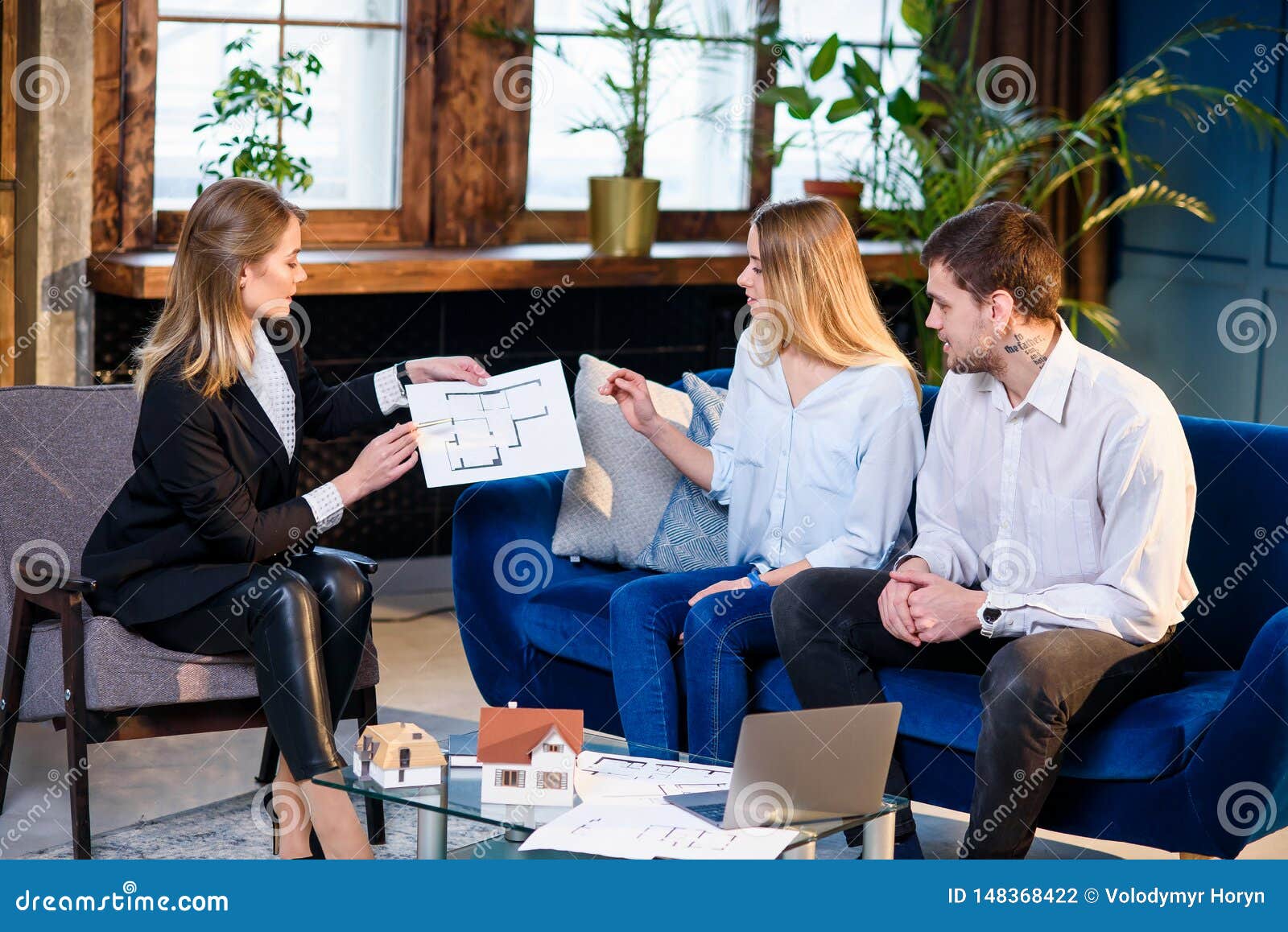 young couple during meeting with realtor, interior er, decorator.