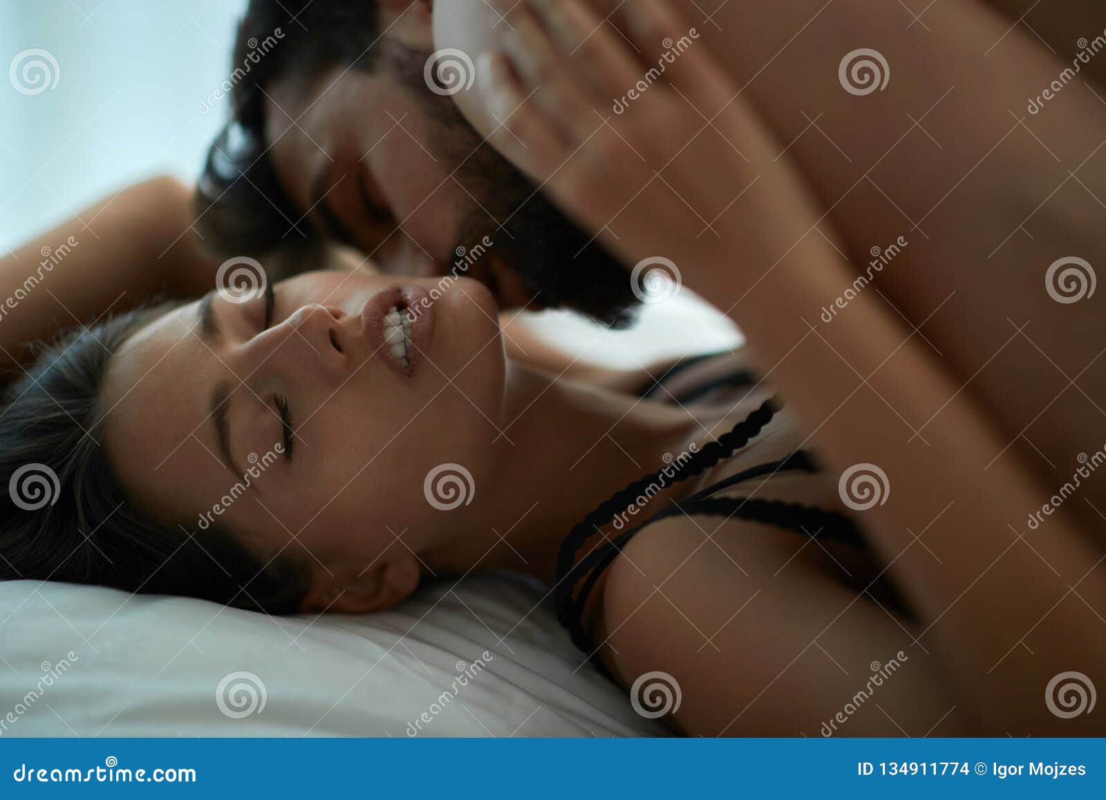 Couple Man and Woman Making Love Having Passionate Sex on Bed, Enjoying Pleasant Sensation Stock Photo