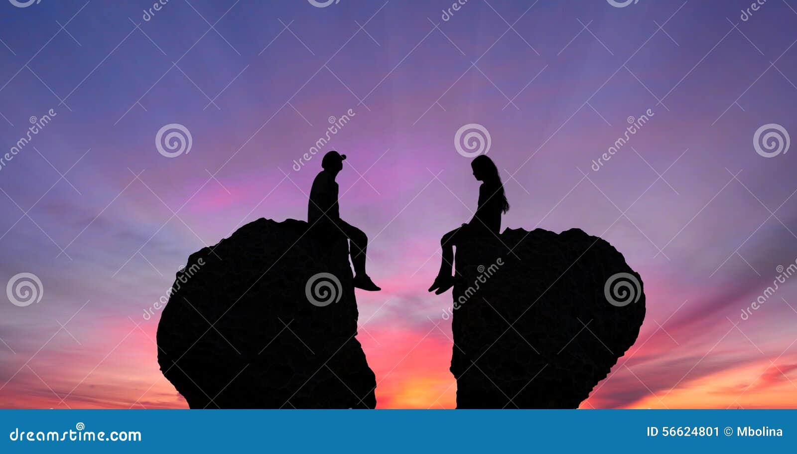 young couple in quarrel sitting on rocks