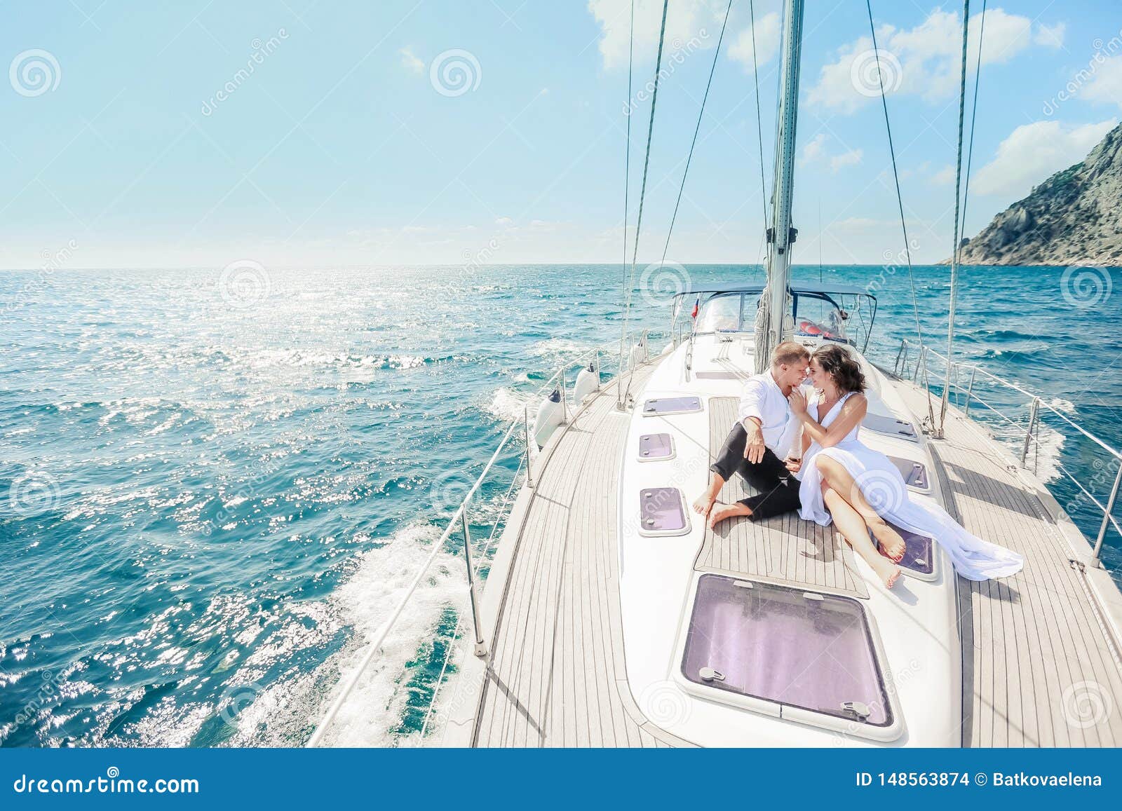 young couple relaxing on a yacht. happy wealthy man and a woman by private boat have sea trip.