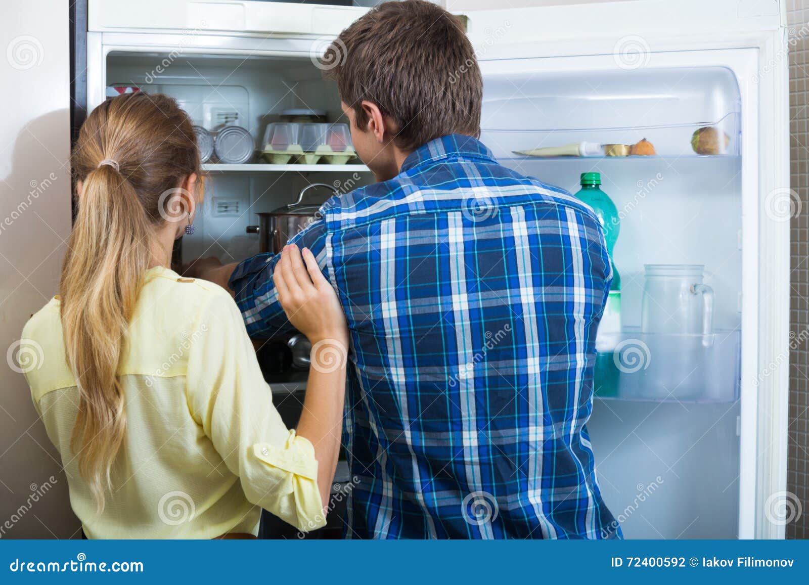 young couple searching food at refrigerator