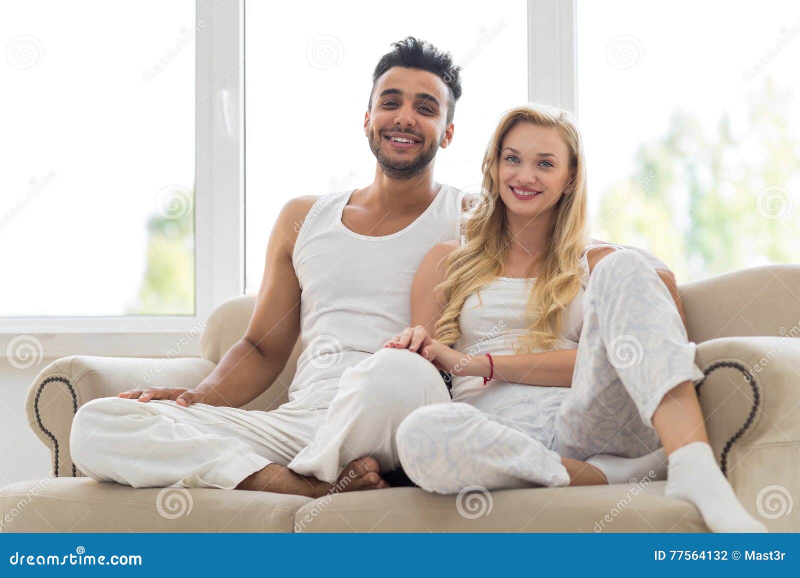 Young Couple Sit On Couch Happy Smile Hispanic Man And Woman Hug