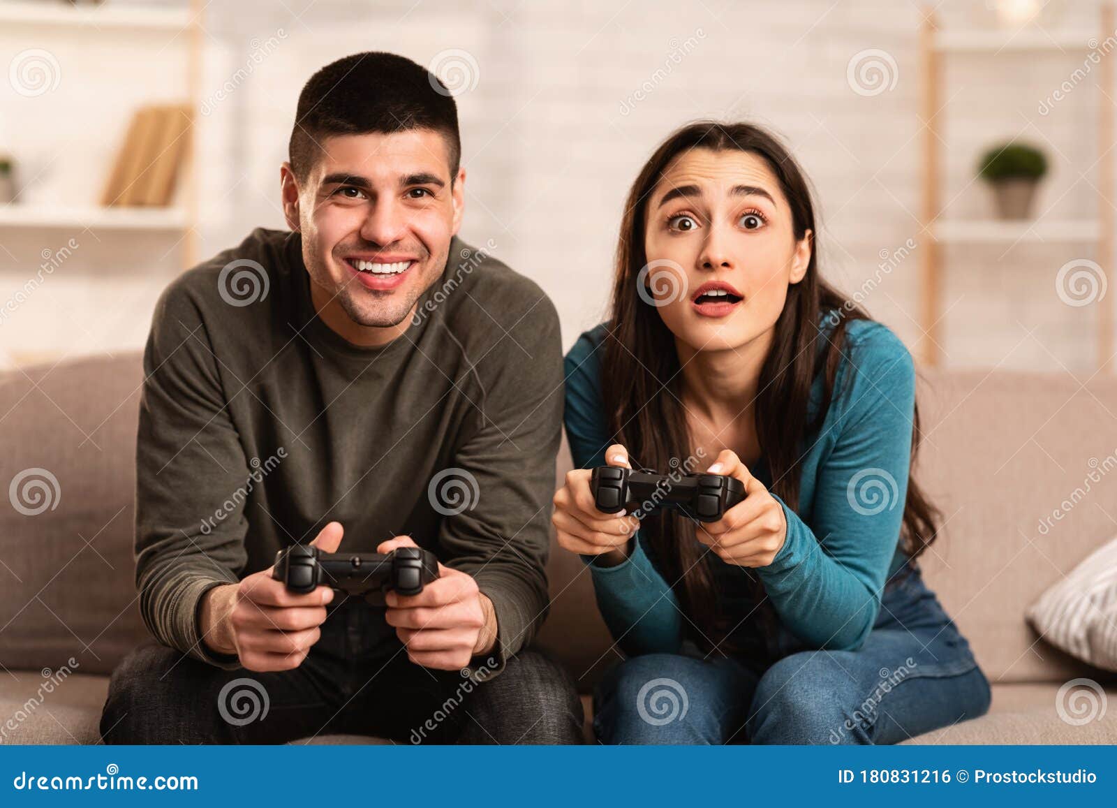 Young Cute Competitive Boyfriend Girlfriend Playing Video Games In Couch  Stock Photo, Picture and Royalty Free Image. Image 34313215.