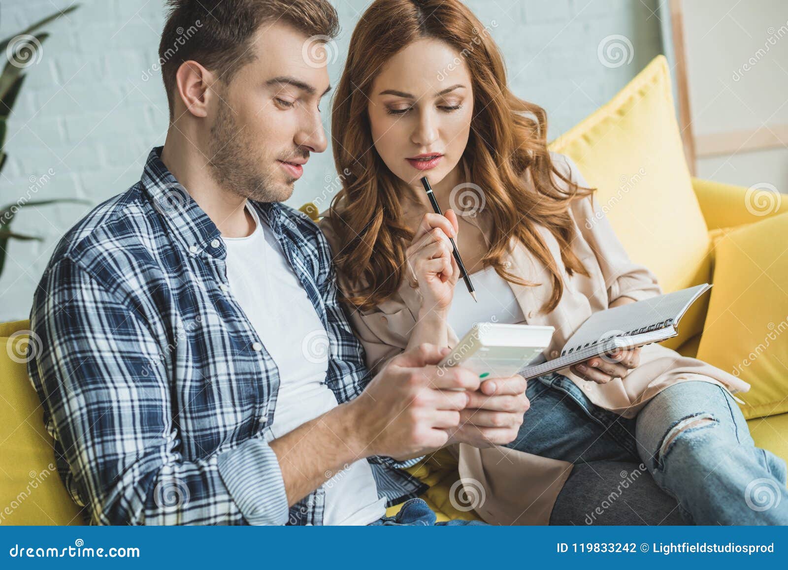 Young Couple Taking Notes and Using Calculator Stock Photo Image of