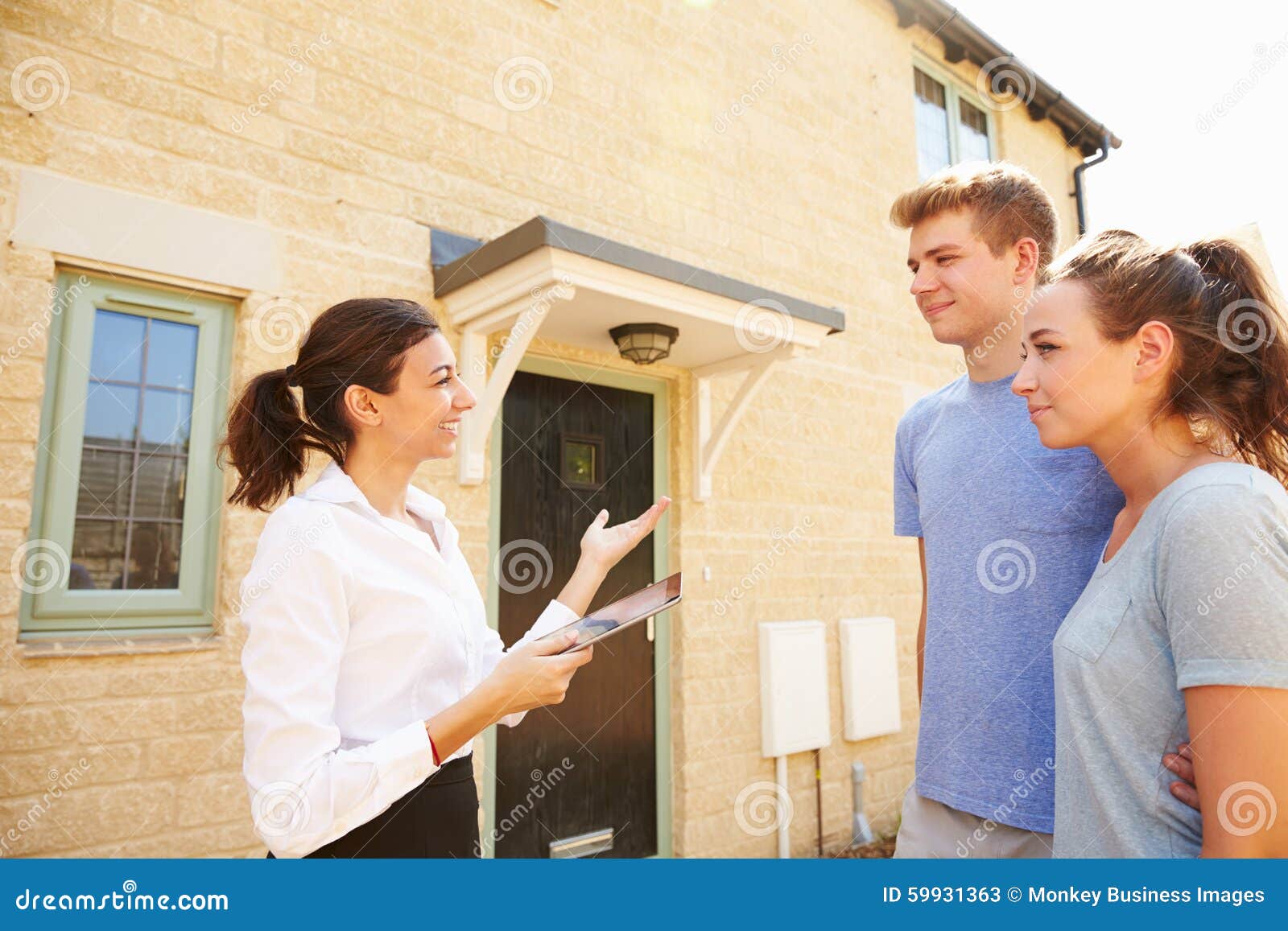 young couple viewing a house with female real estate agent