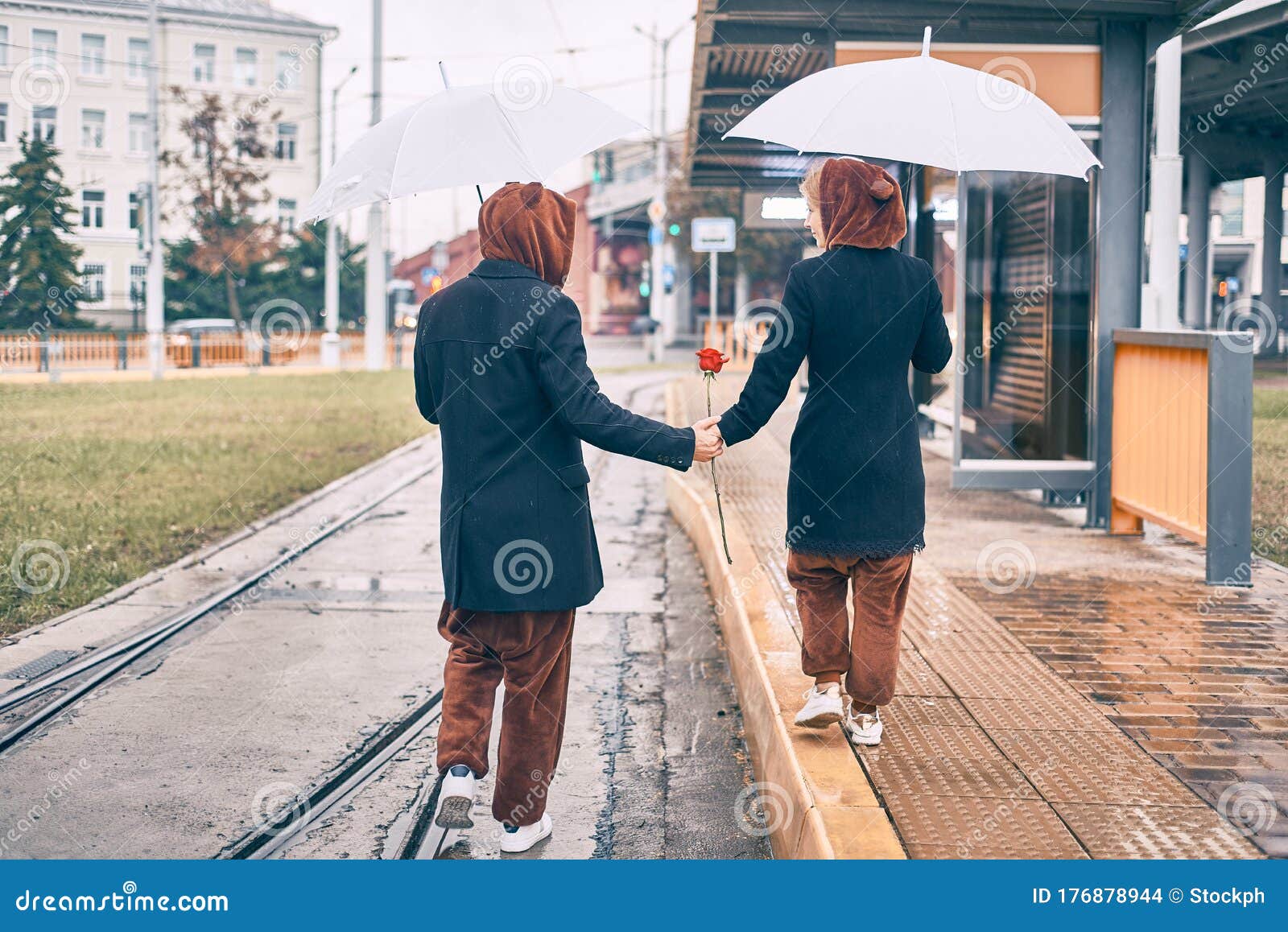 Young Couple (man And Woman), Playfully Walking Along A 