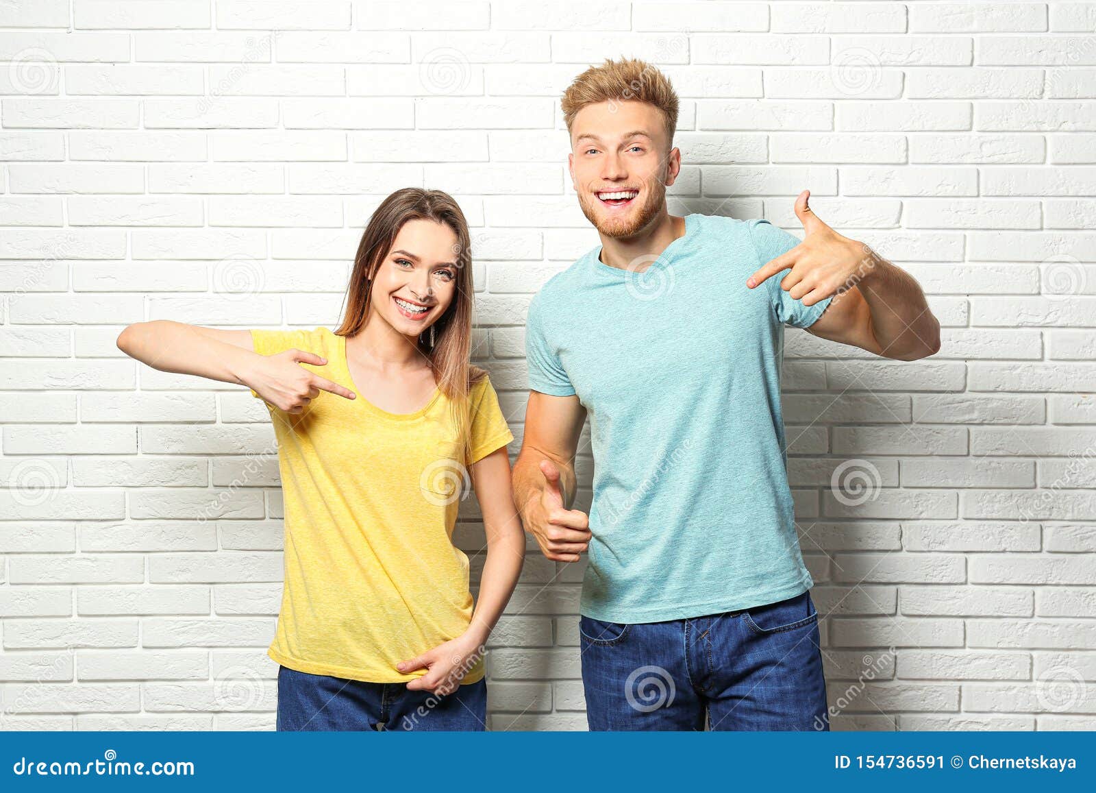 Download Young Couple Wearing Blank T-shirts Near White Brick Wall. Mockup For Stock Image - Image of ...