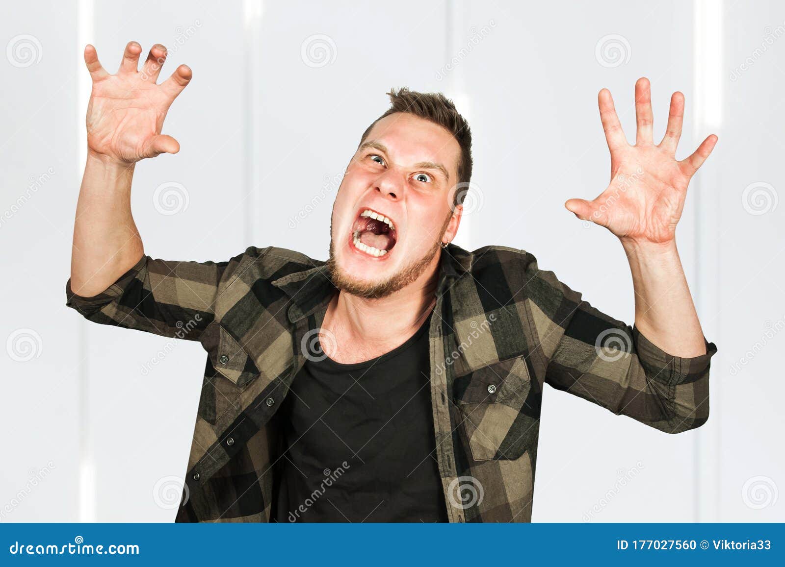 Young Crazy Guy Scares Like a Devil with Hands Up Stock Photo Image