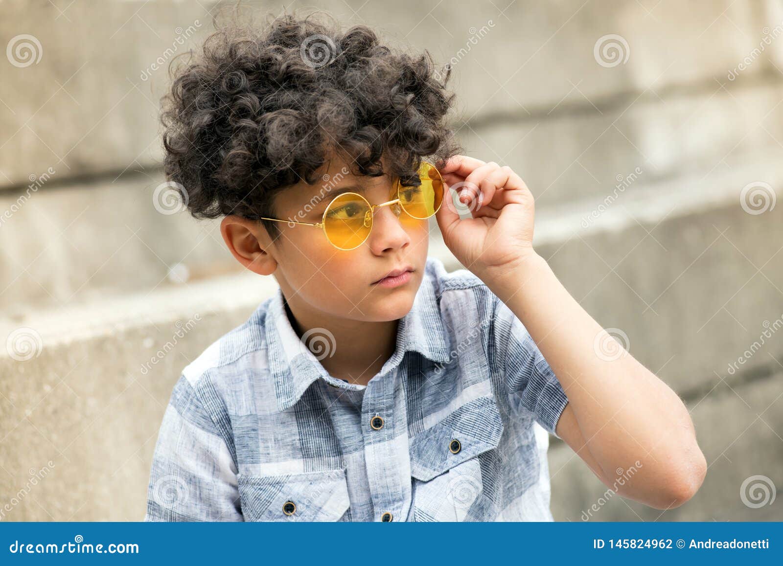 Young Curly Headed Boy with Trendy Yellow Shades Stock Photo - Image of hair,  serious: 145824962