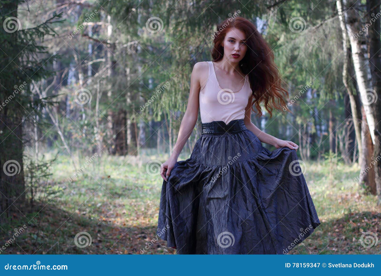 Beautiful young woman in print bare shoulder top and long skirt poses near  a metal wall Stock Photo | Adobe Stock