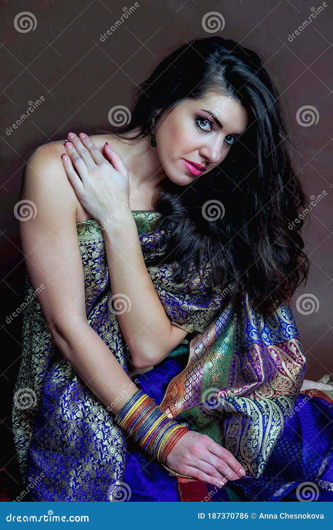 The Young Dark Haired Woman In A Bright Indian Sari And Colored