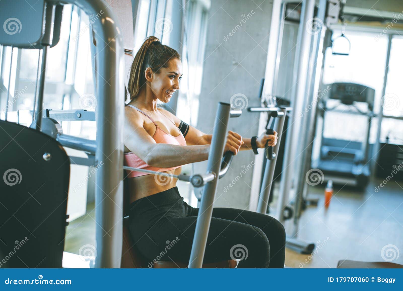 Young Determined Fitness Woman Doing Exercises at Chest Press