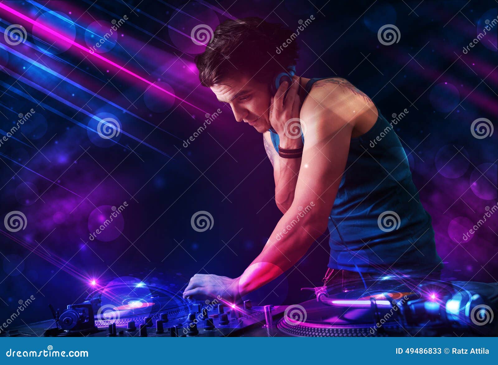 Young DJ Playing on Turntables with Color Light Effects Stock Image