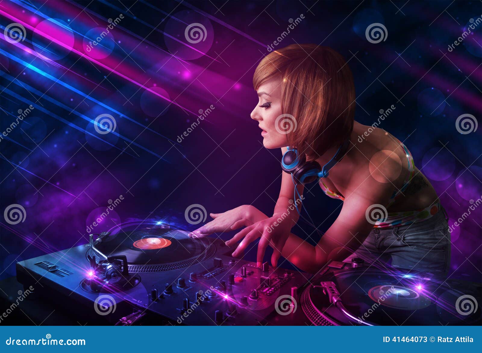 Young DJ Playing on Turntables with Color Light Effects Stock Image