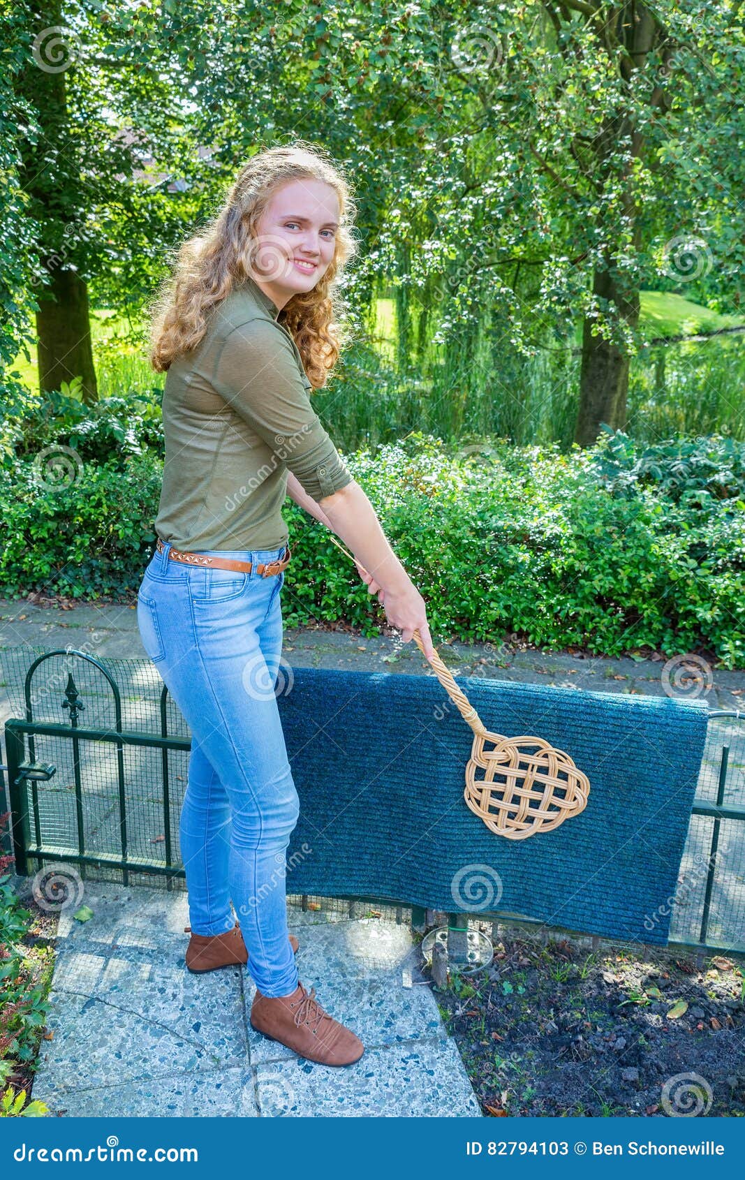 Young Dutch Woman Beating Door Mat with Carpet Beater Stock Image