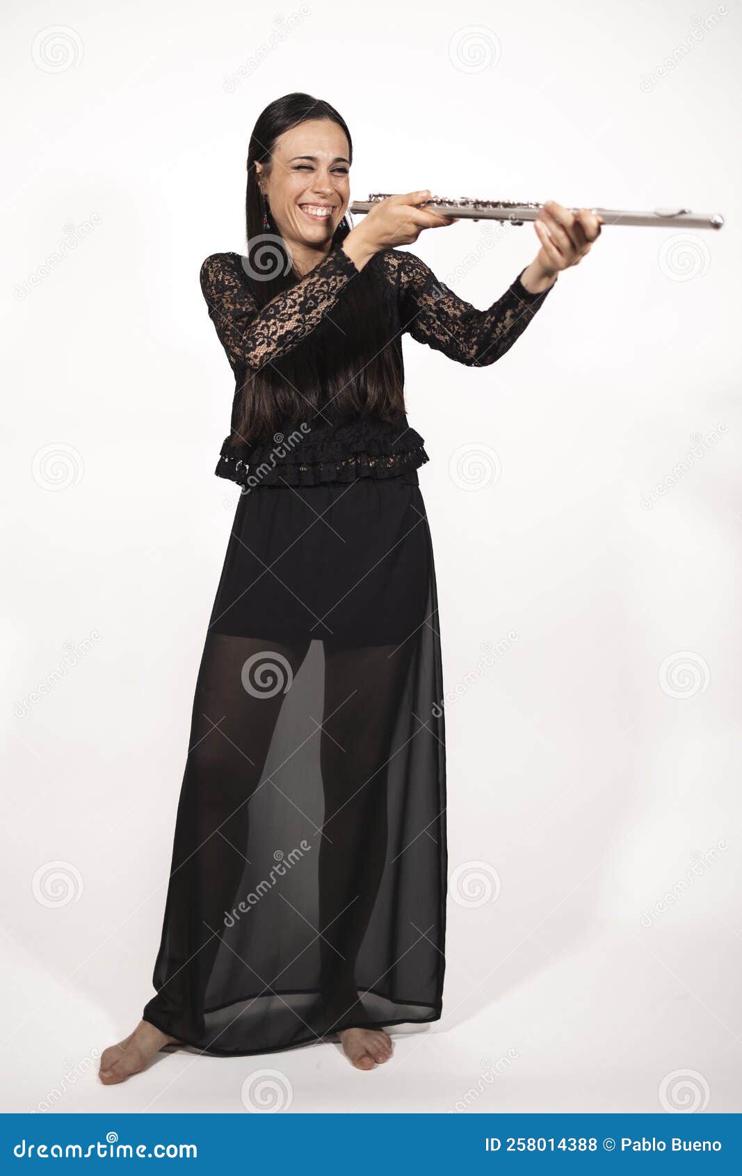 A Young Elegant Female Flutist Checking Her Instrument Stock Photo