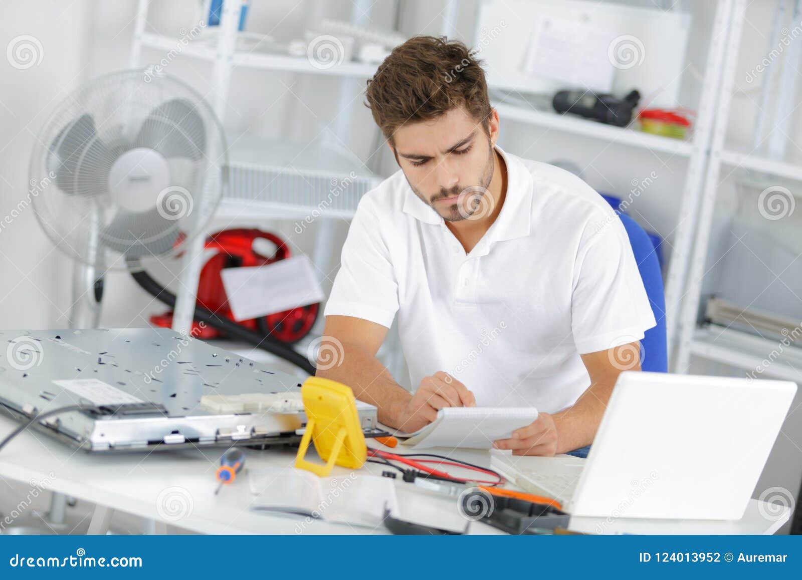 young engineer taking notes while developping new induction hobs