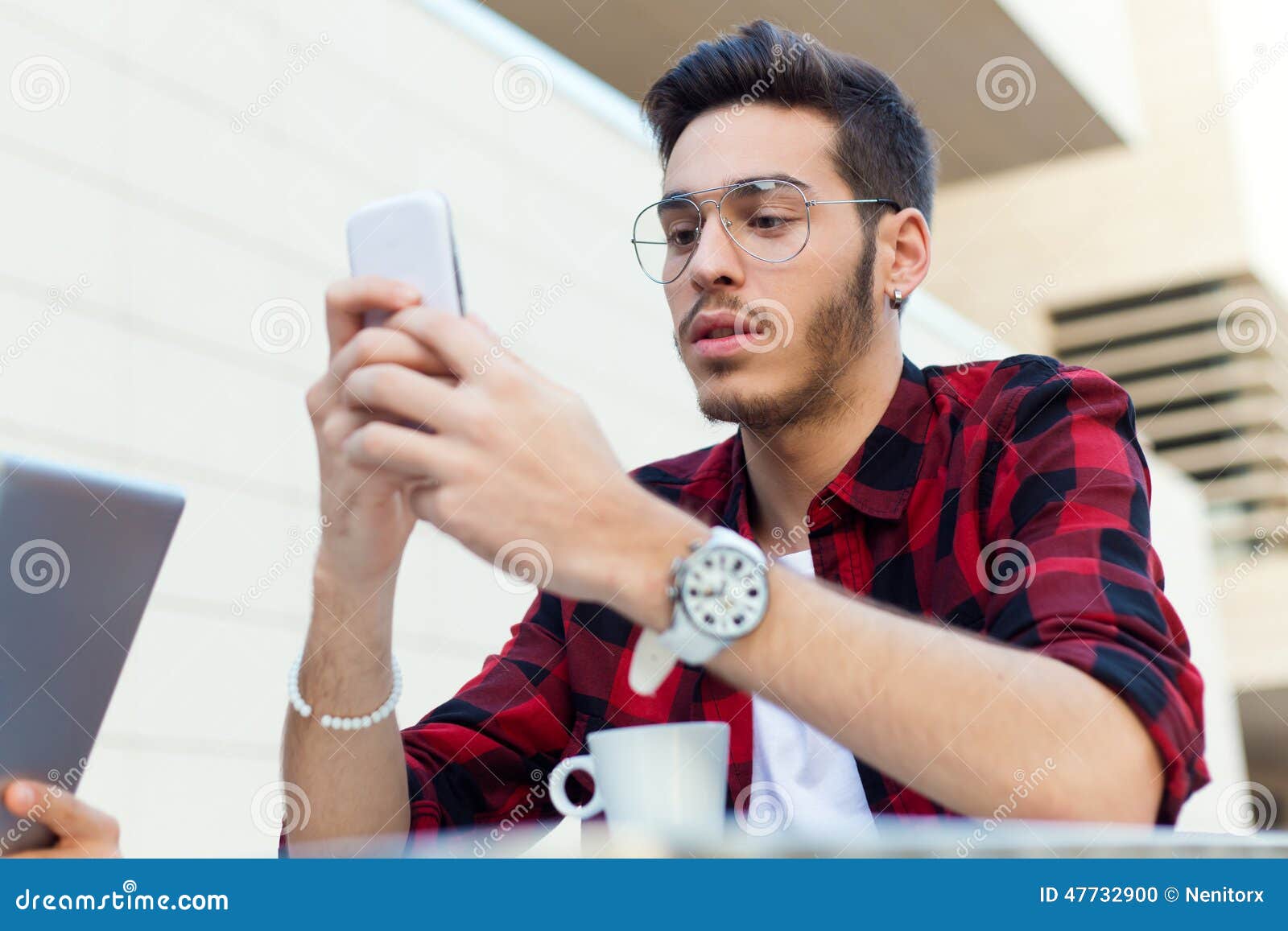 Young Entrepreneur  Using His Mobile  Phone At Coffee Shop 