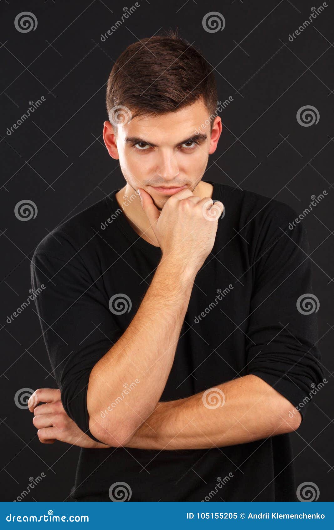 A Young European Guy Poses Holding One Hand Against His Chin Against A Black Background Indoors Stock Image Image Of Look Casual