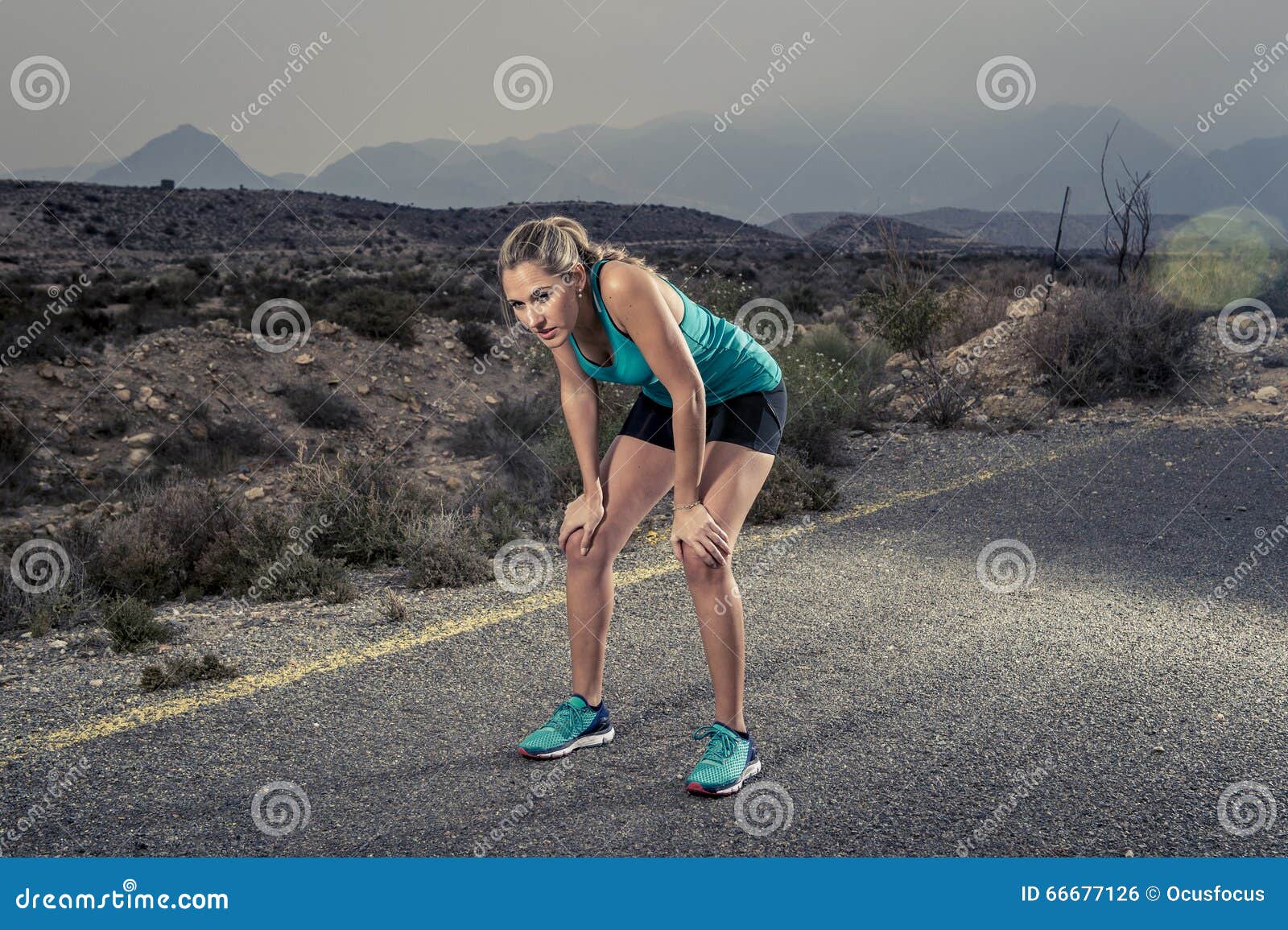 young exhausted sport woman running outdoors on asphalt road breathing