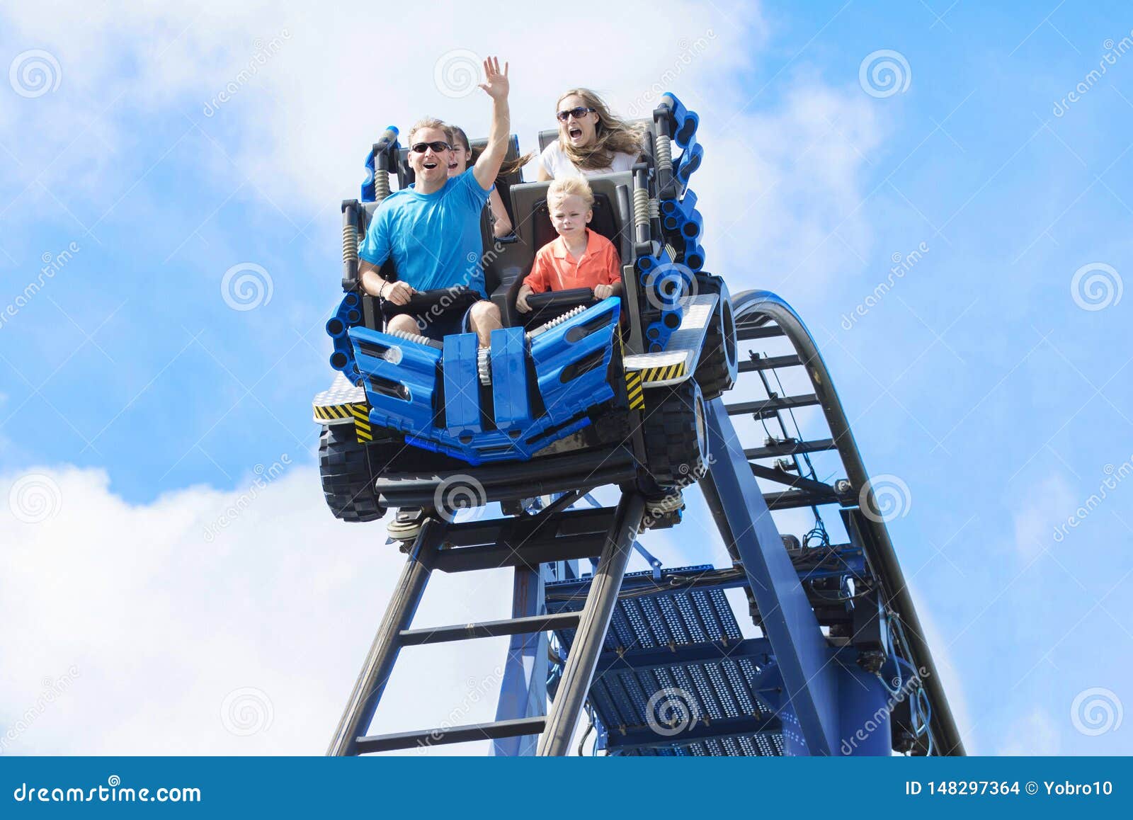 young family having fun riding a rollercoaster at a theme park