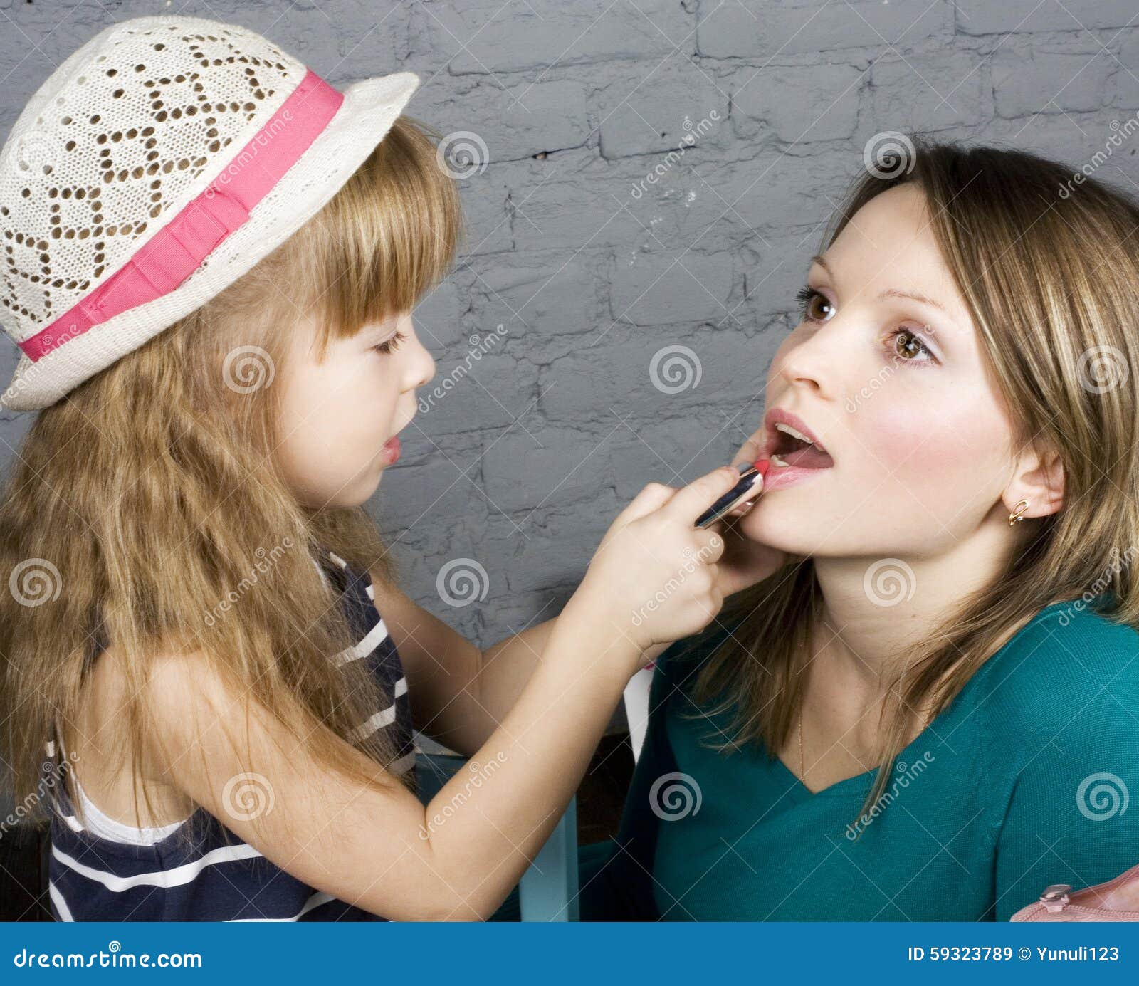 Young Family Mother And Daughter Make Up At Mirror