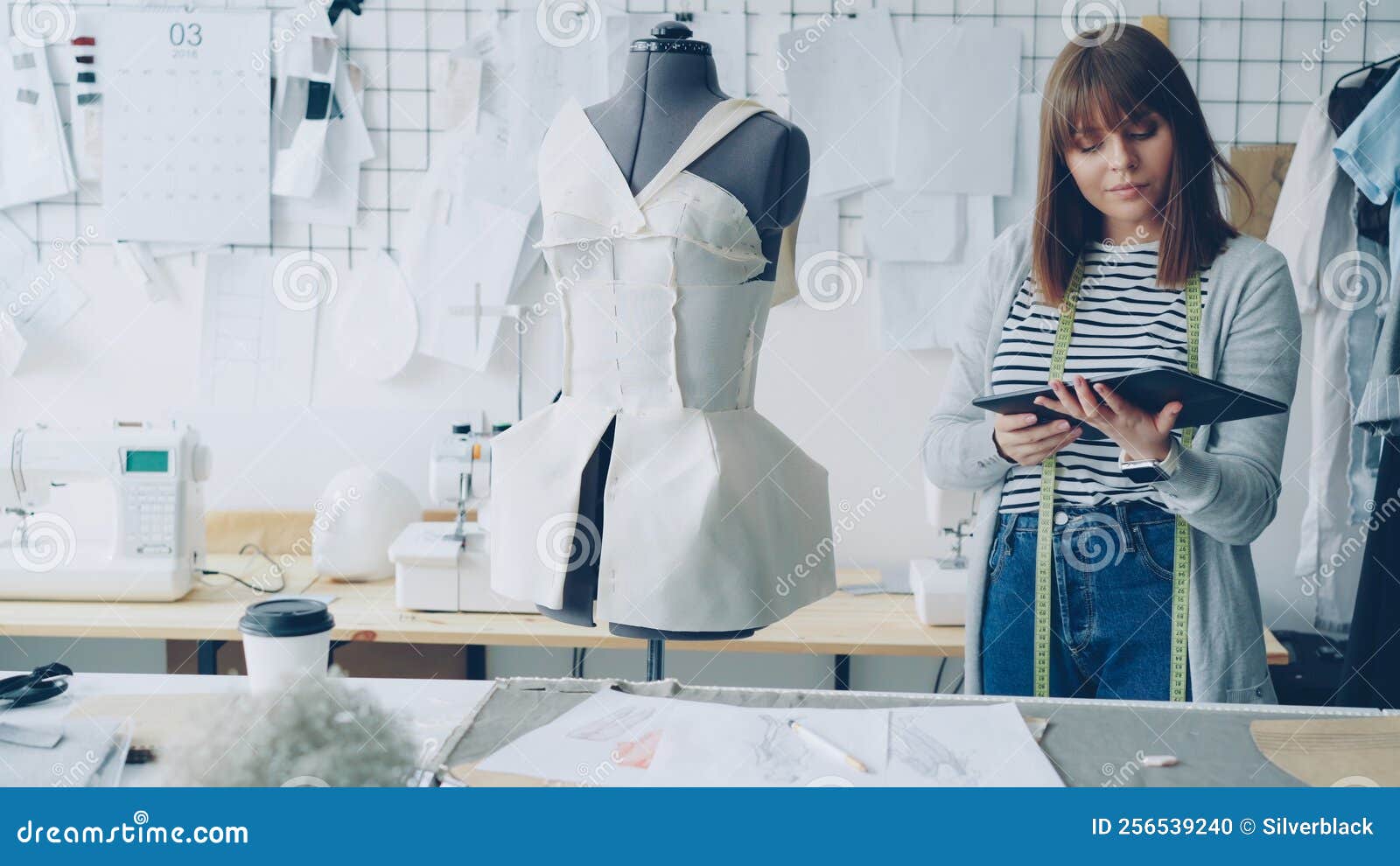 Young Fashion Designing Entrepreneur is Working with Tablet while ...